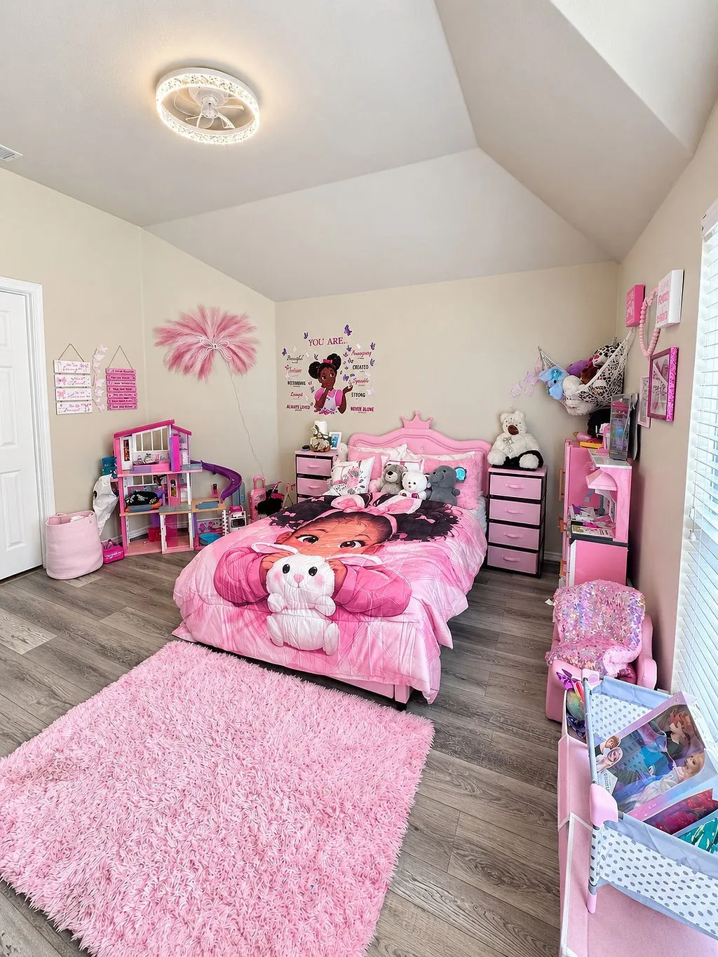 Sloped ceiling design, wood-finish flooring, and a ceiling-mounted light fixture