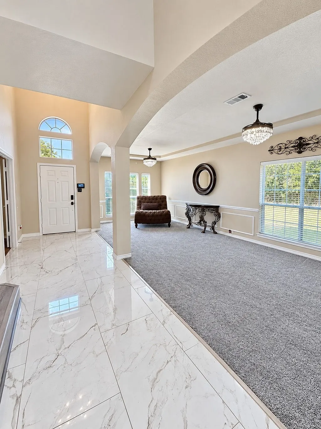 Entryway featuring high ceilings, a decorative arch, and polished tile flooring