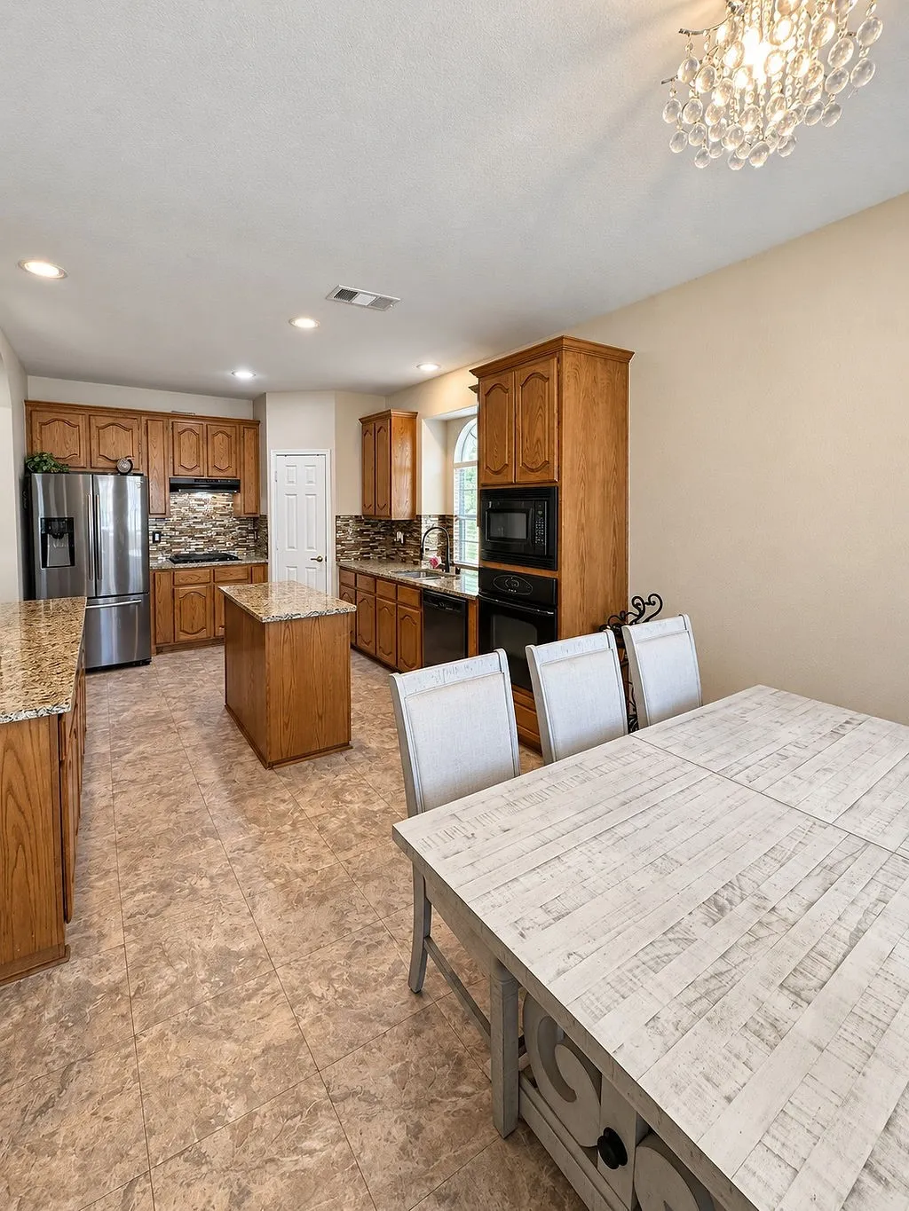 Kitchen featuring wood cabinetry, granite countertops, a central island, stainless steel appliances, and recessed lighting