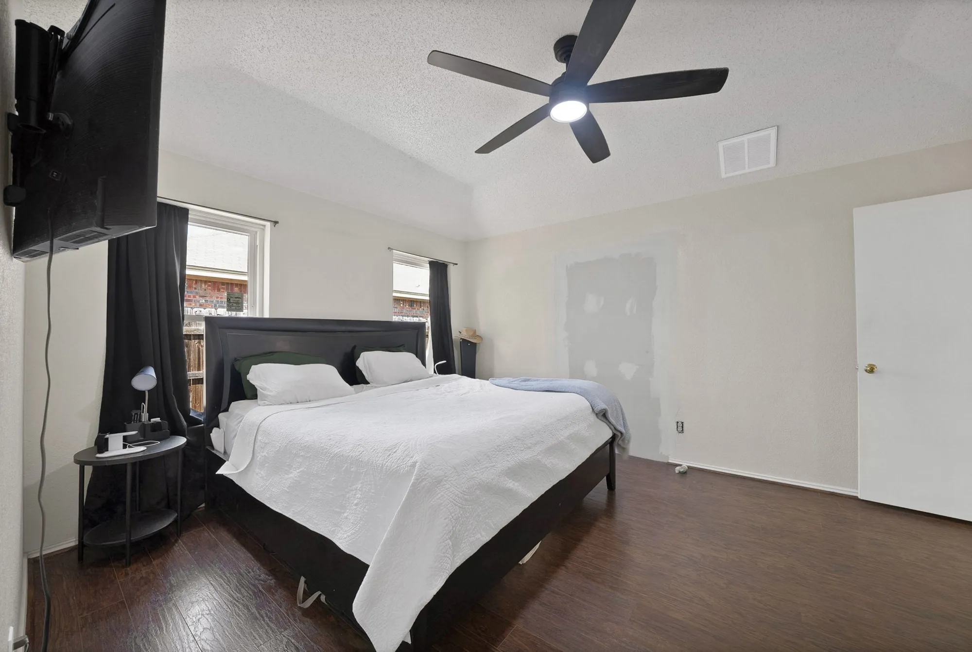 Wood-finish flooring, vaulted ceilings, and a ceiling fan with integrated lighting