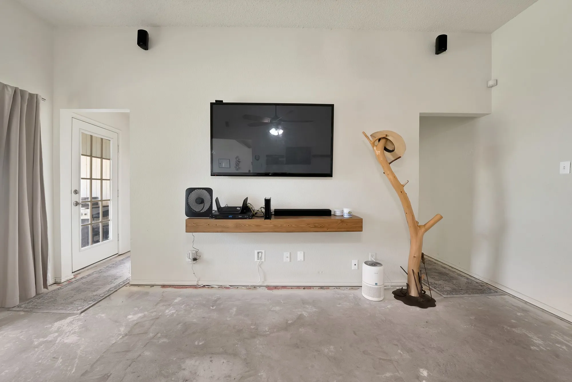 White wall finishes with a floating wood-finish shelf