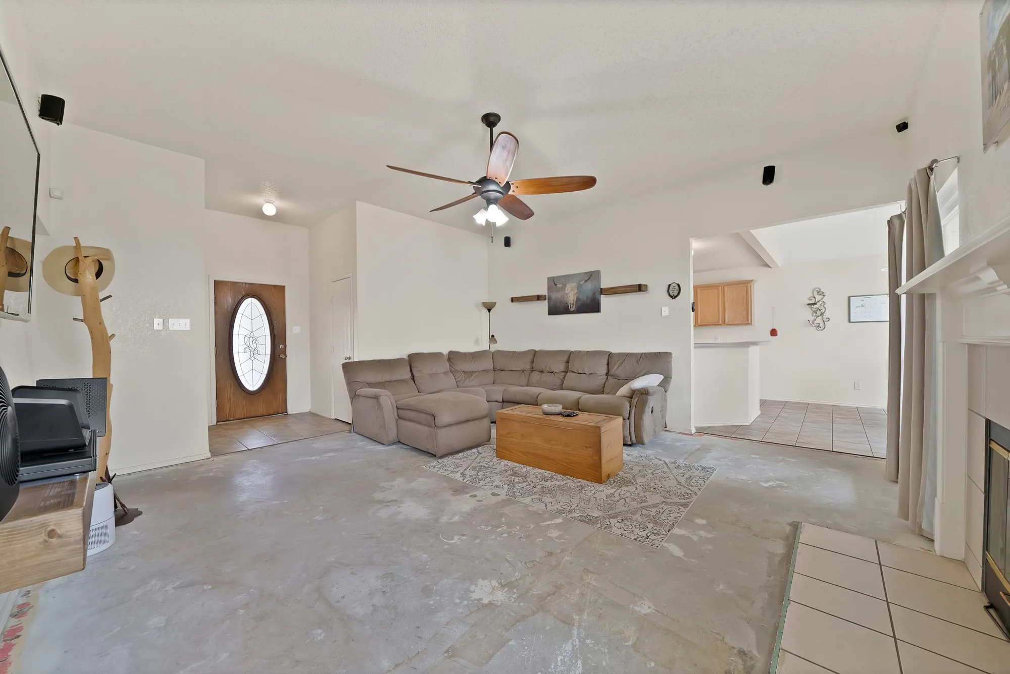 Open-concept living area with a ceiling fan, recessed lighting, and a front entry door with an oval glass insert