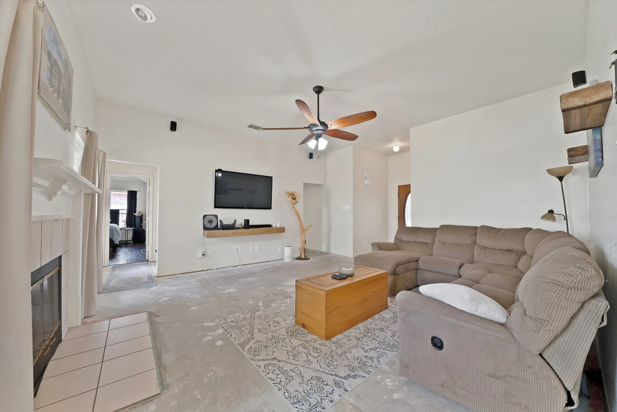Living area with a vaulted ceiling, recessed lighting, and a ceiling fan