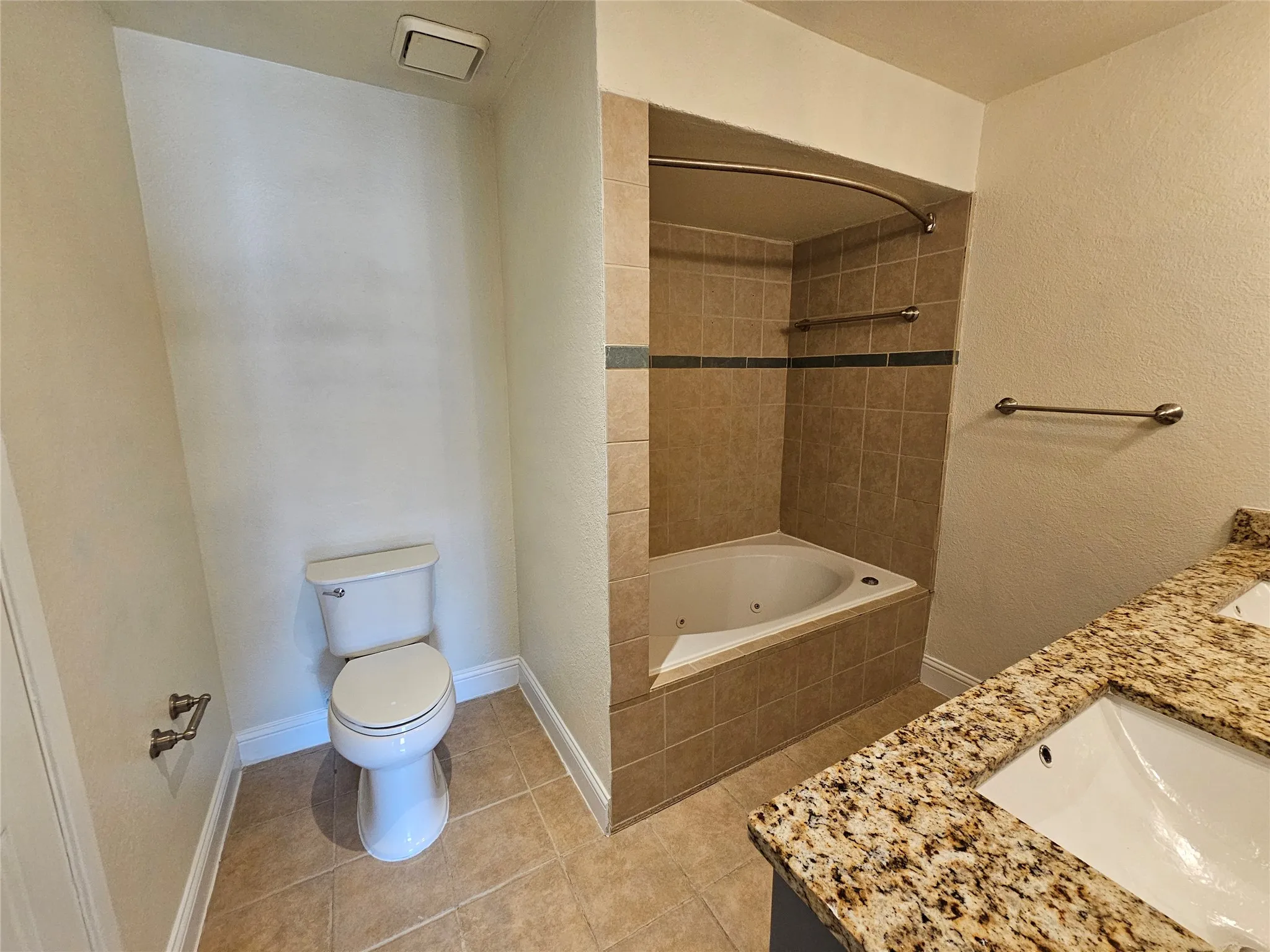 Dual vanity with granite countertops, undermount sinks, and an integrated jetted tub