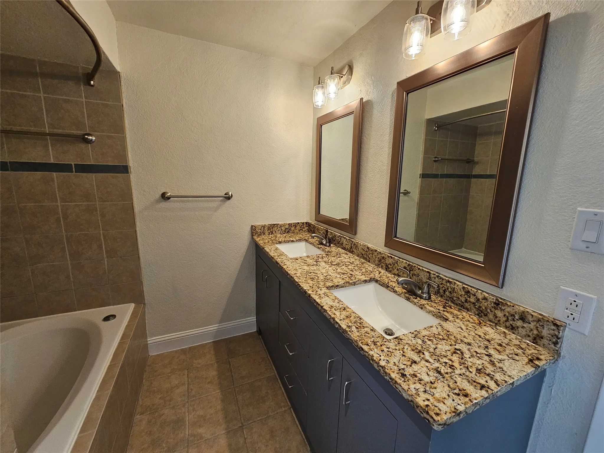 Dual vanity with undermount sinks, granite countertop, and built-in cabinetry