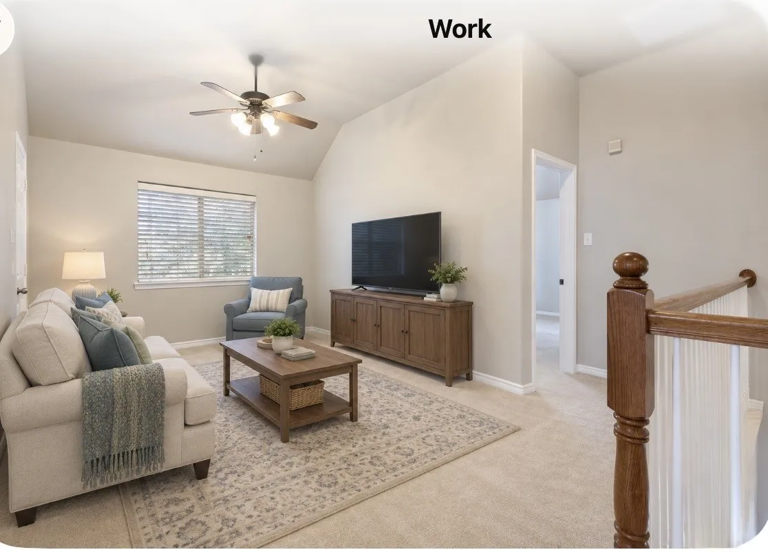 Virtural staging:Vaulted ceiling with a ceiling fan, neutral wall tones, window with blinds, wood-finish media console, and wood-finish stair railing