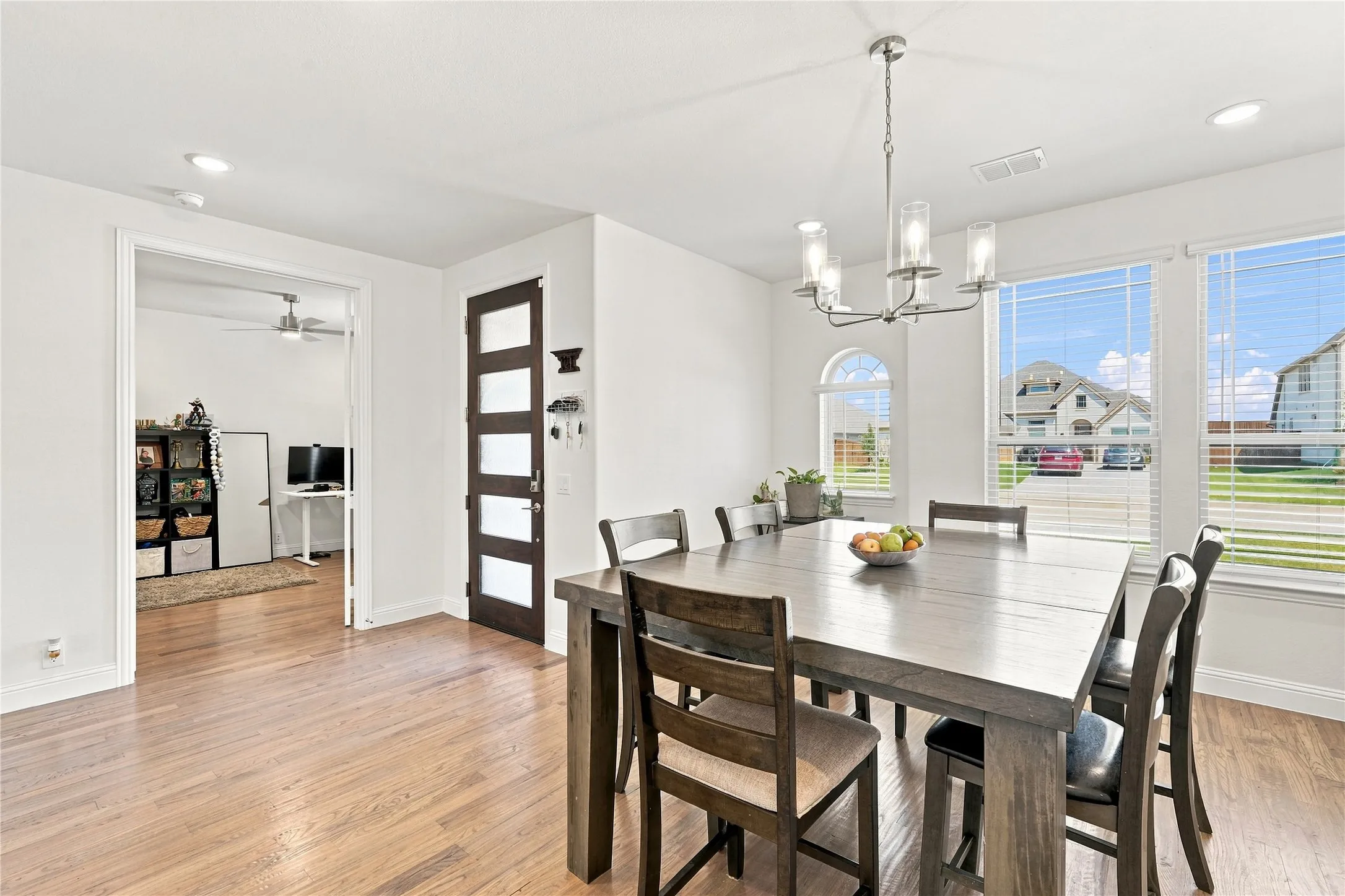 Wood-finish flooring throughout, recessed lighting, and a modern chandelier
