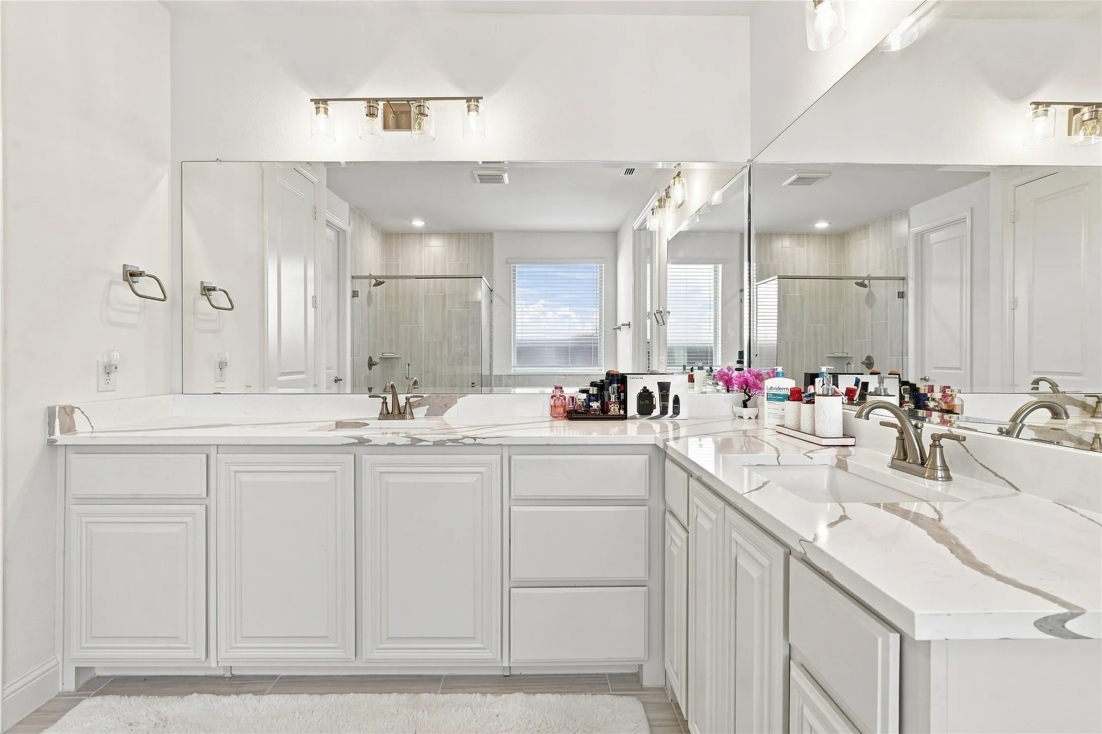 Dual vanity with light-toned countertops and integrated sinks