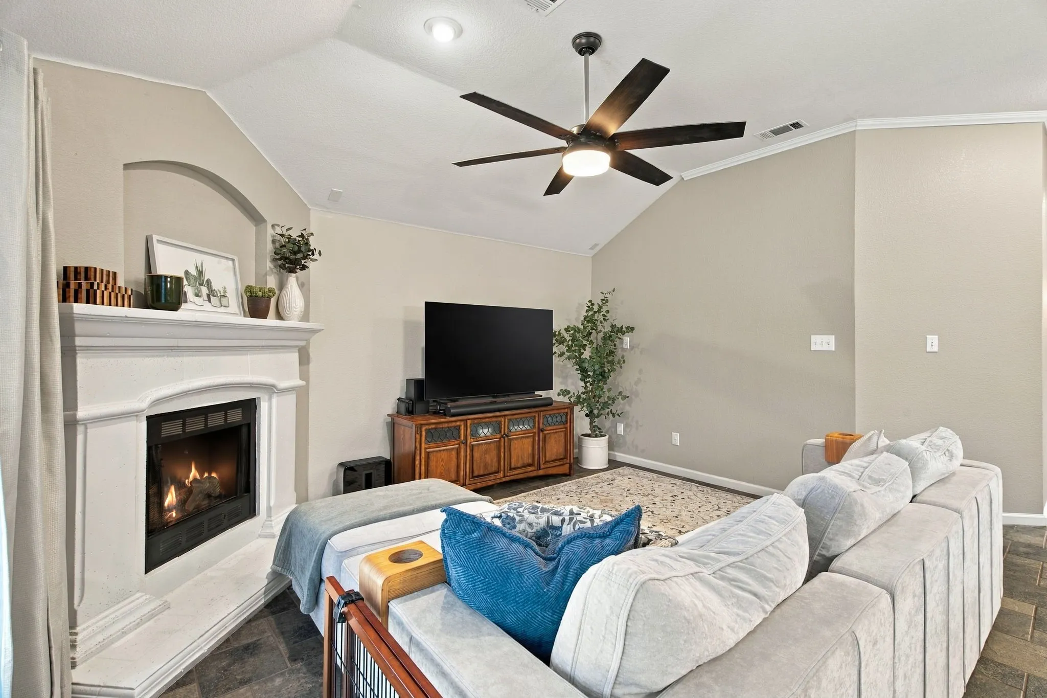 Vaulted ceiling with an integrated ceiling fan, recessed lighting, a built-in fireplace with a stone hearth, and tile flooring