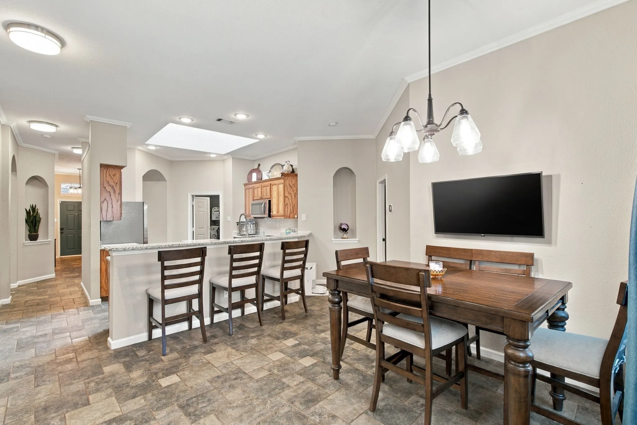 Kitchen bar with light-toned countertop, vaulted ceiling, recessed lighting, and a skylight
