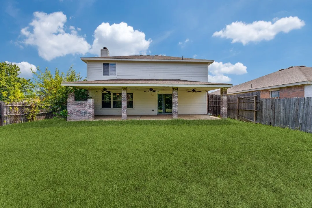 Rear view of property featuring a ceiling fan, a patio area, a fenced backyard, and a chimney