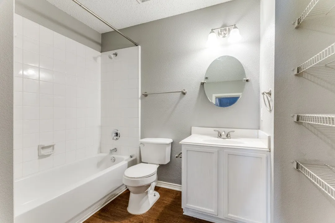 Bathroom with shower / bathtub combination, a textured wall, dark wood-type flooring, vanity, and a textured ceiling
