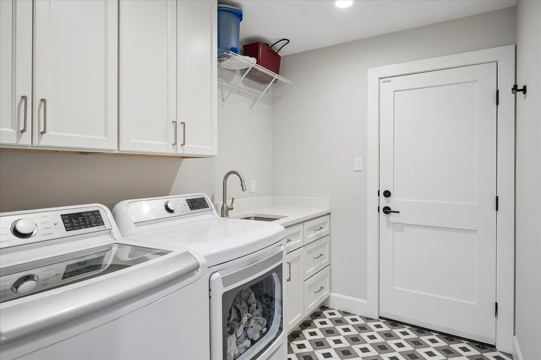 White shaker cabinetry, patterned floor tiling, undermount sink, and recessed lighting