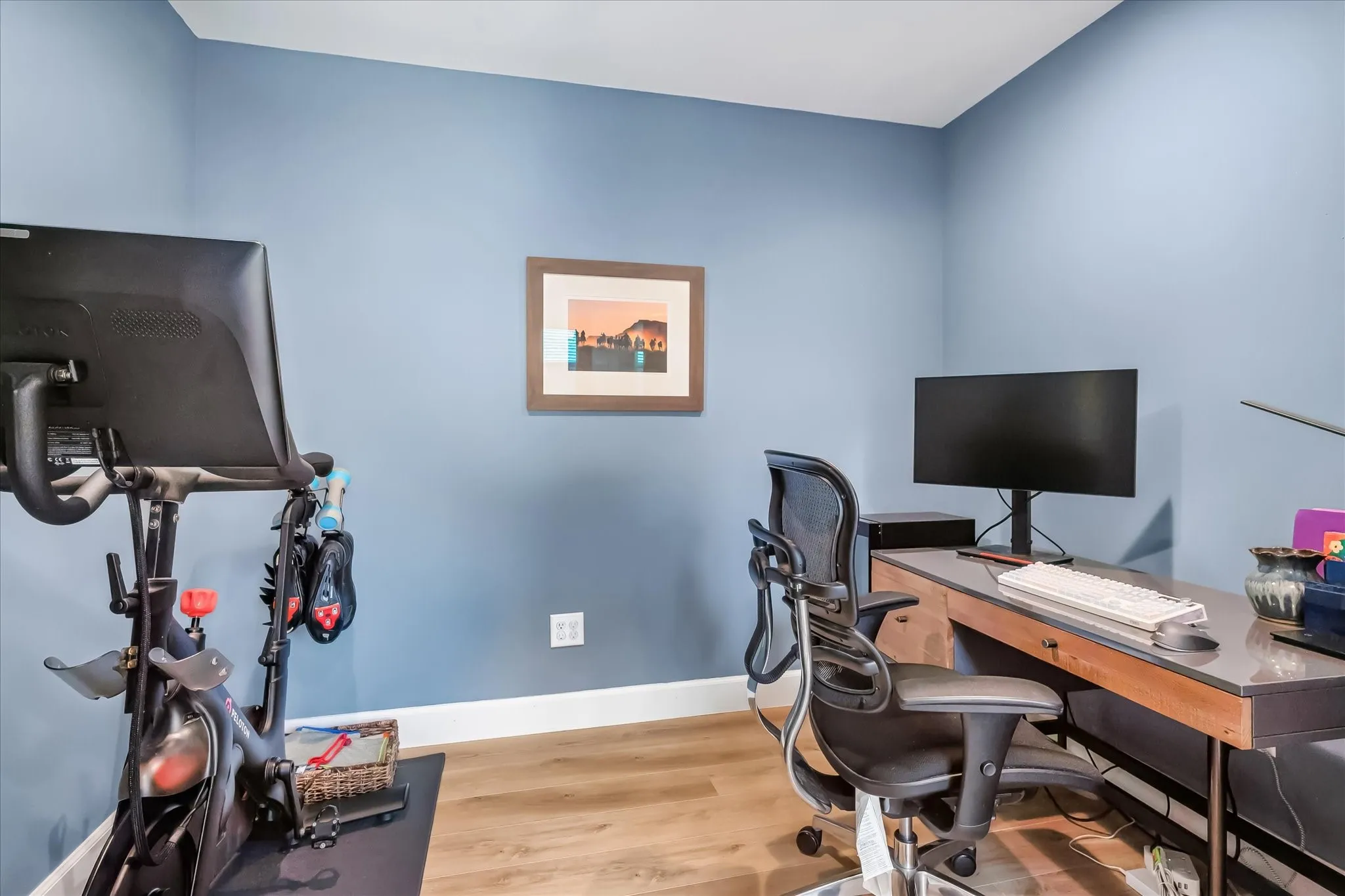 Wood-finish flooring with white trim and blue wall paint