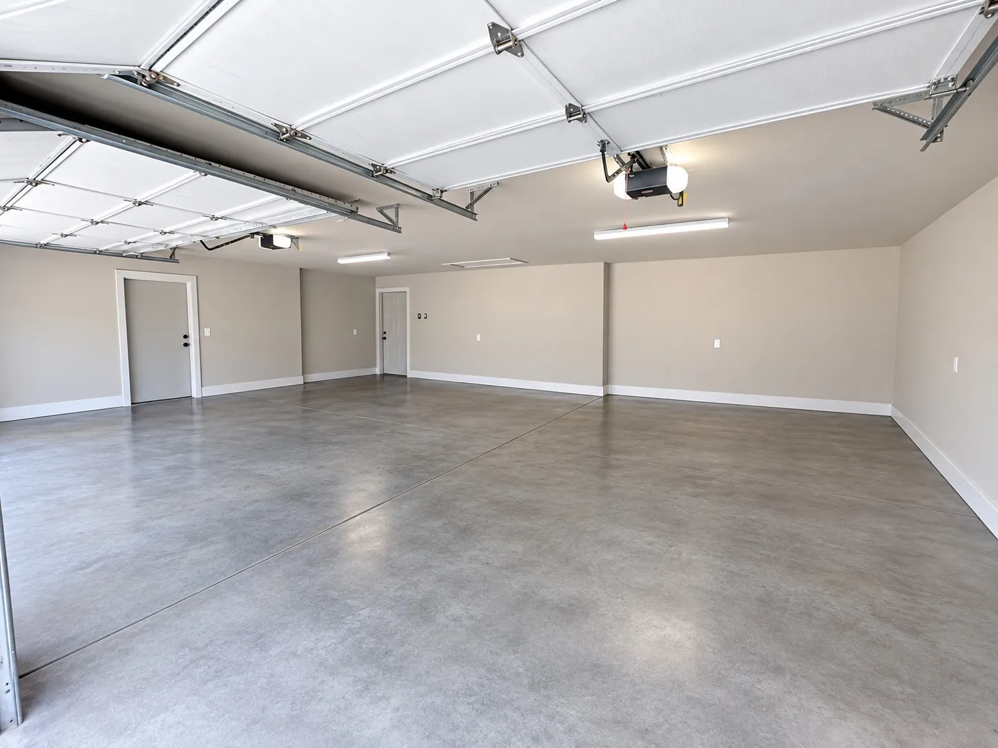 Spacious garage with light grey painted walls and a smooth concrete floor