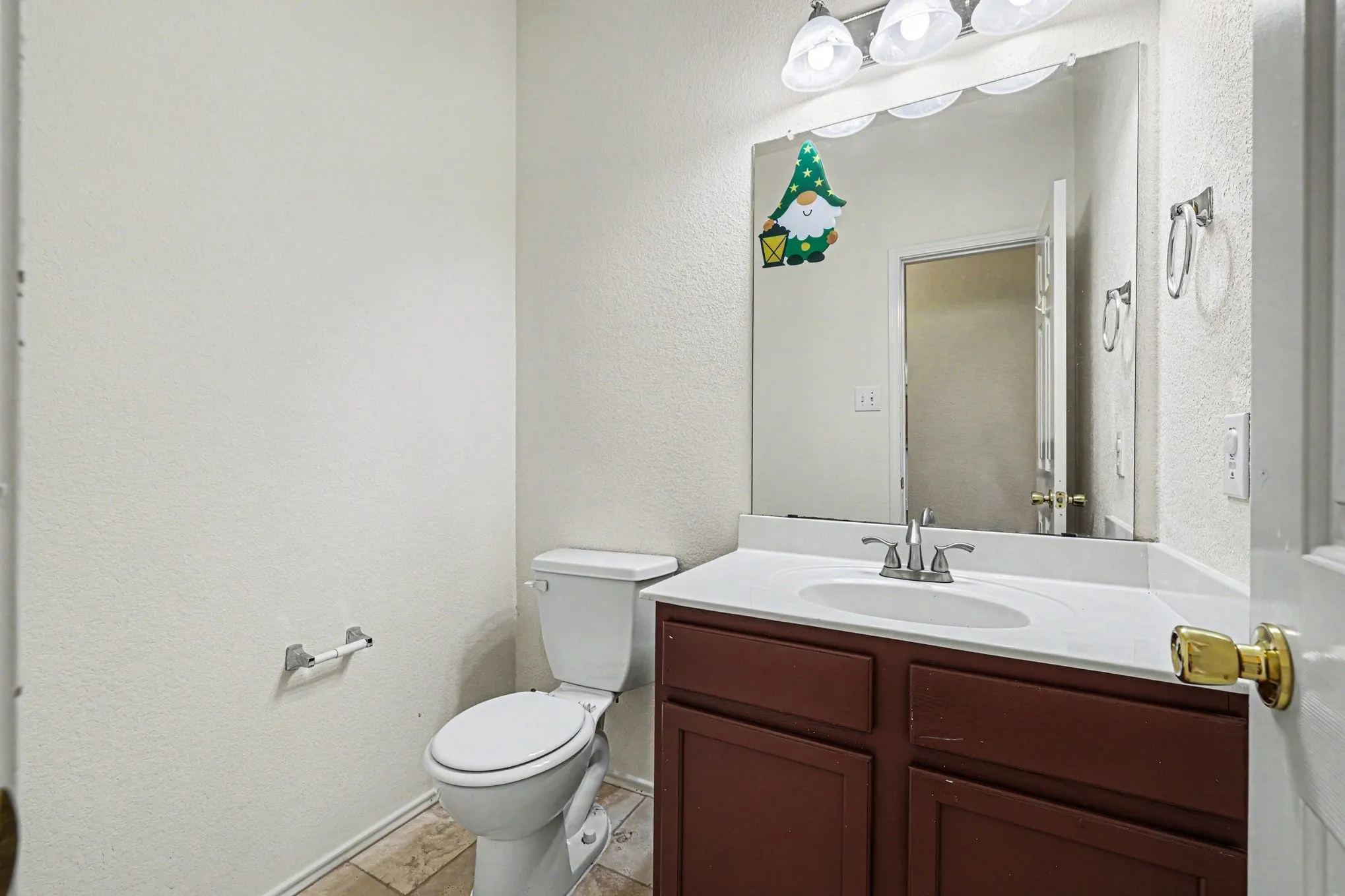 Vanity with a white countertop and integrated sink, chrome faucet, and brown wood-finish cabinetry
