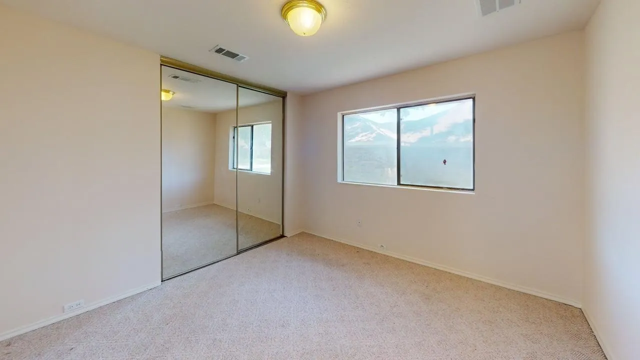 Recessed lighting, mirrored closet doors, and broad window