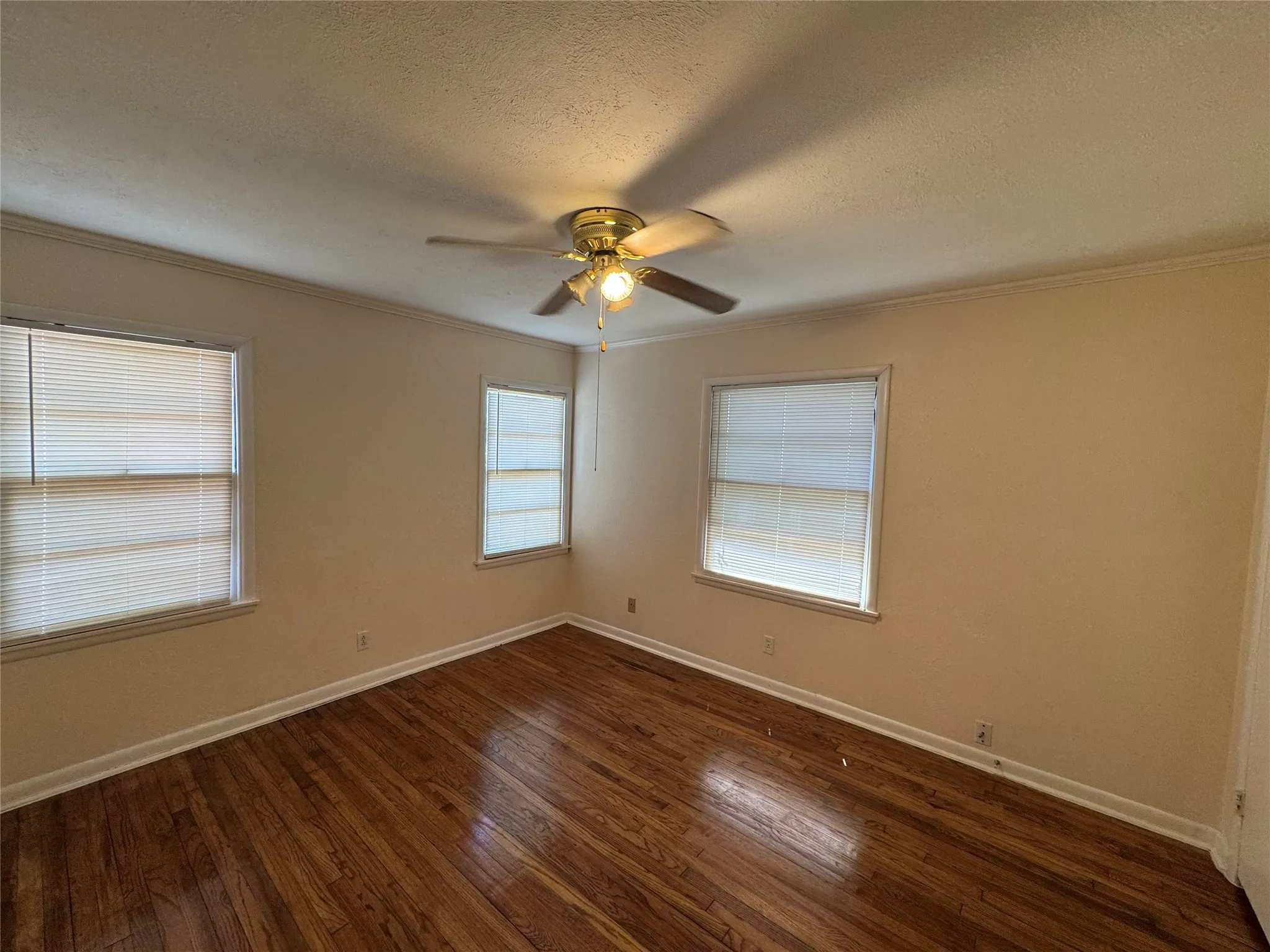 Bedroom with ceiling fan, blinds and crown molding