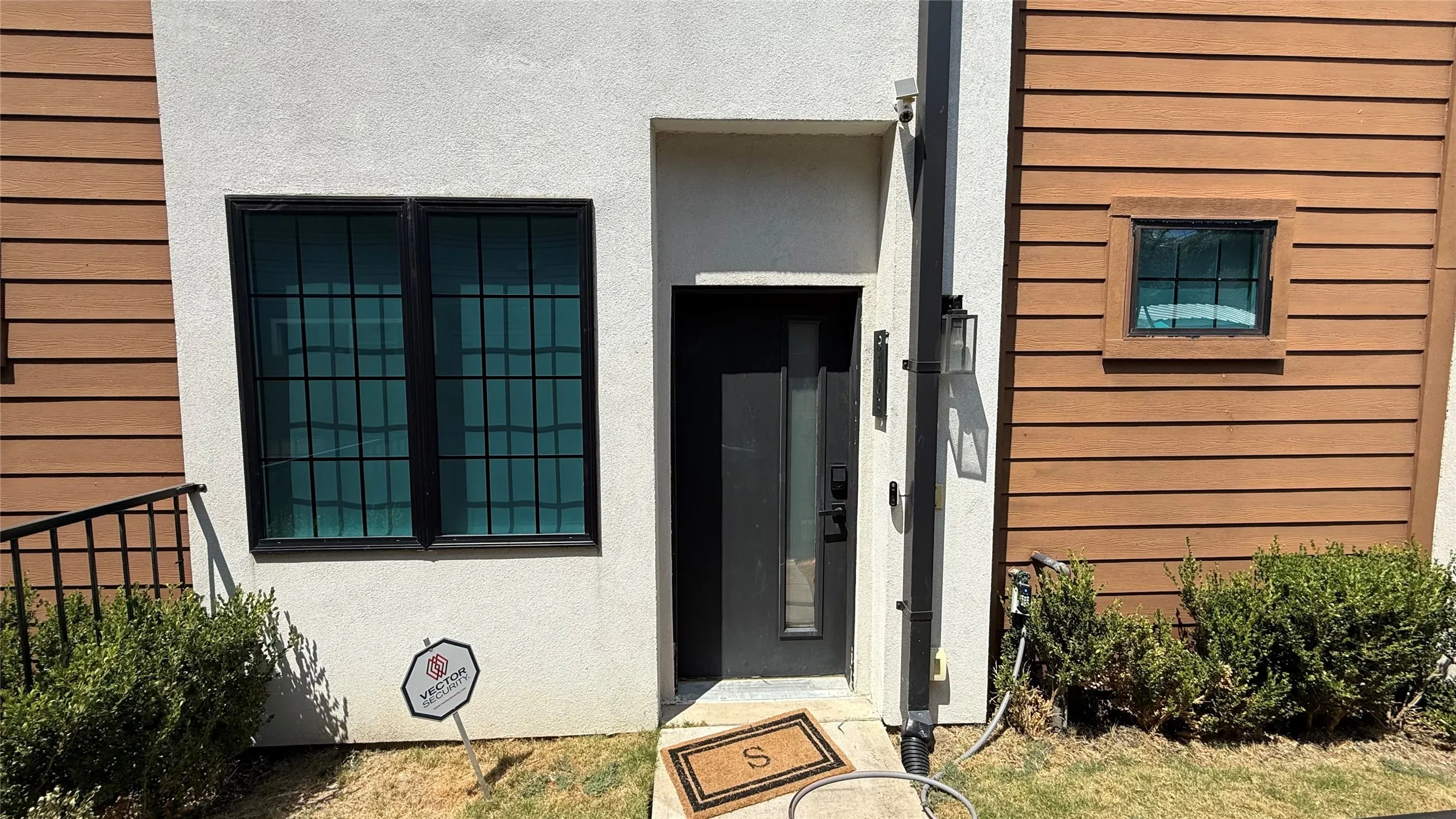 Modern facade featuring horizontal wood-tone siding and stucco finishes