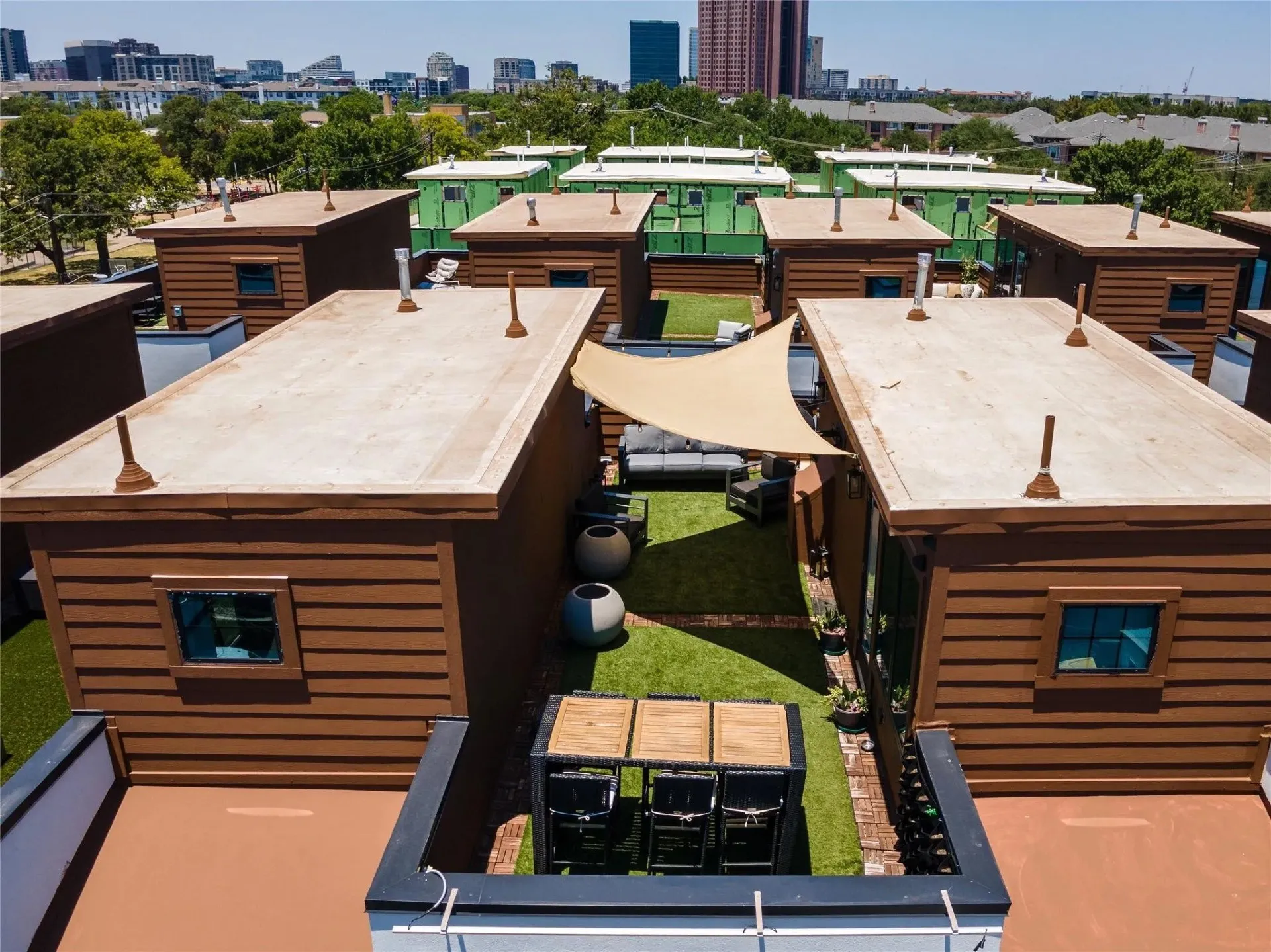Rooftop deck featuring a shade sail, artificial turf, and a dining area
