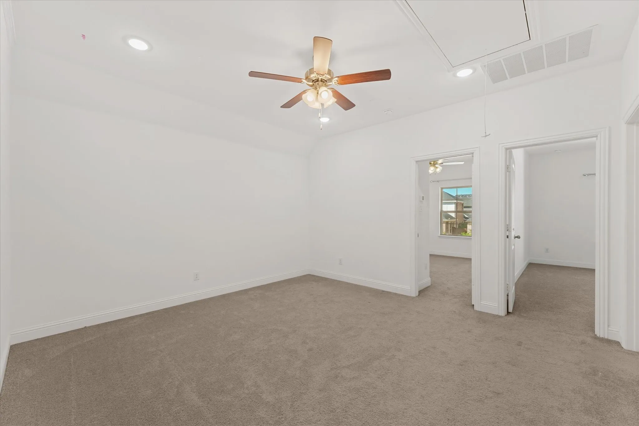 Neutral carpet flooring, recessed ceiling lighting, a ceiling fan, and white painted walls