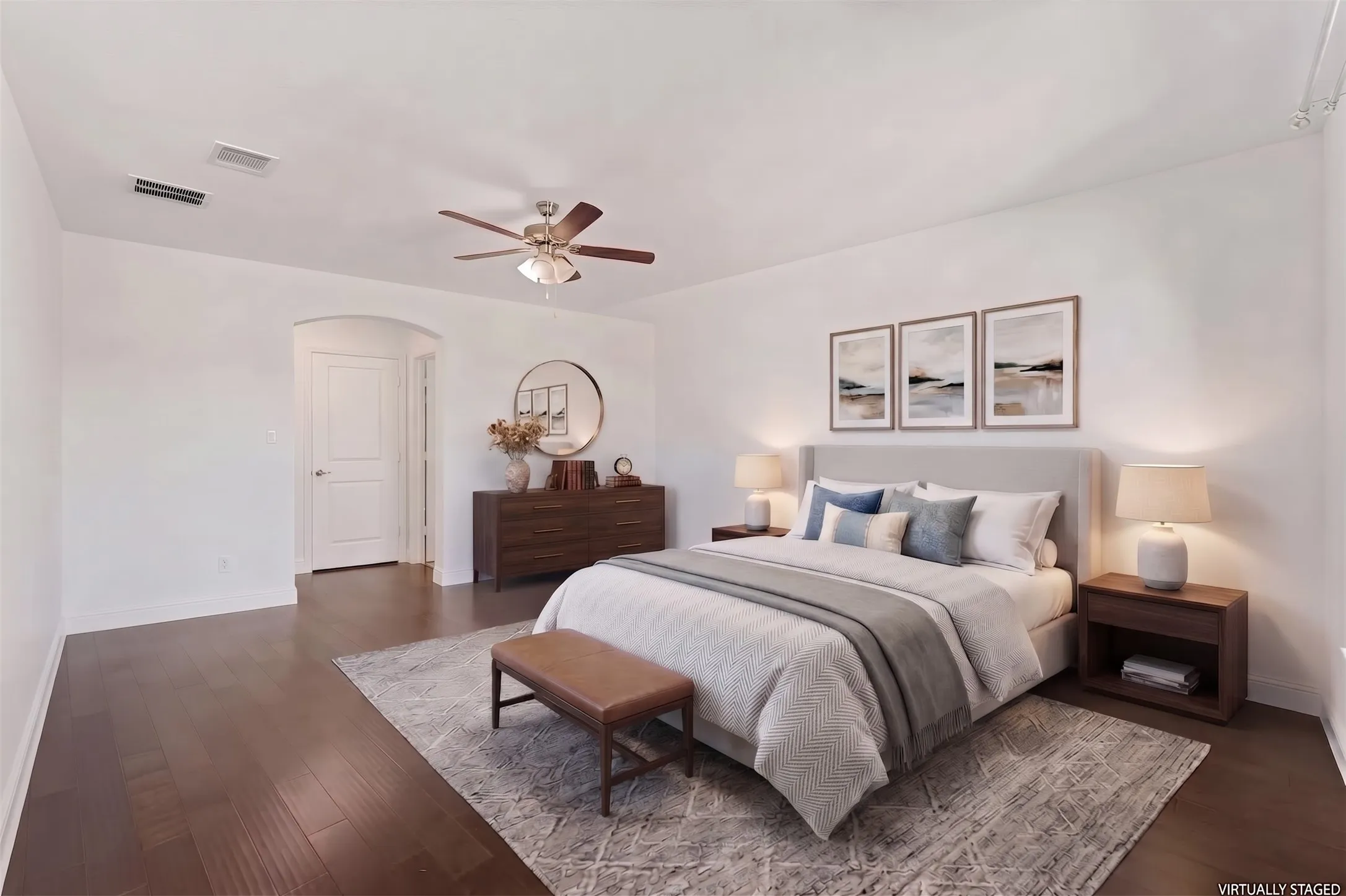 Dark wood-finish flooring, white walls, arched doorway, ceiling fan with integrated lighting - Virtually Staged