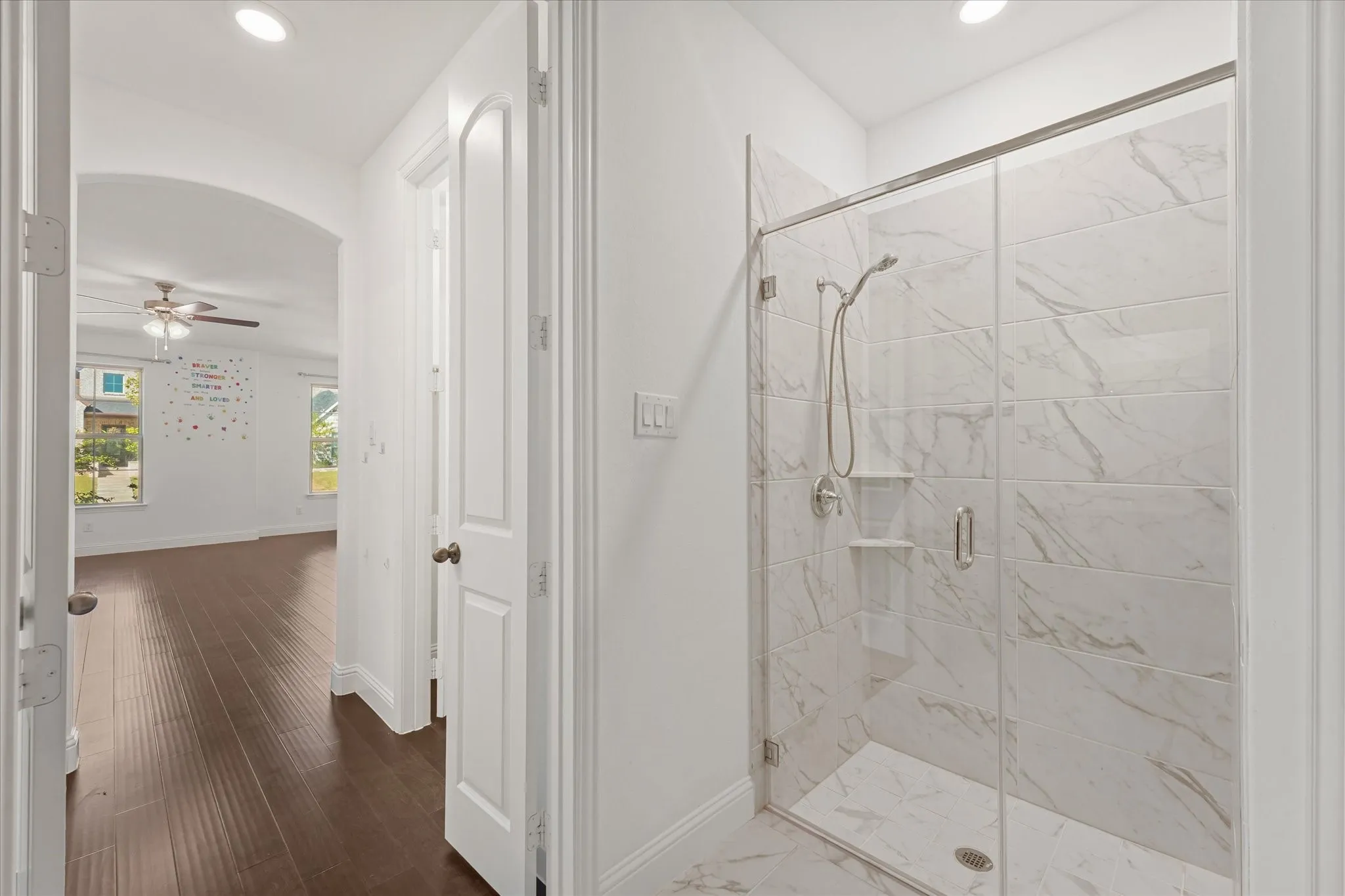 Walk-in shower with clear glass enclosure and subway-style tile surround