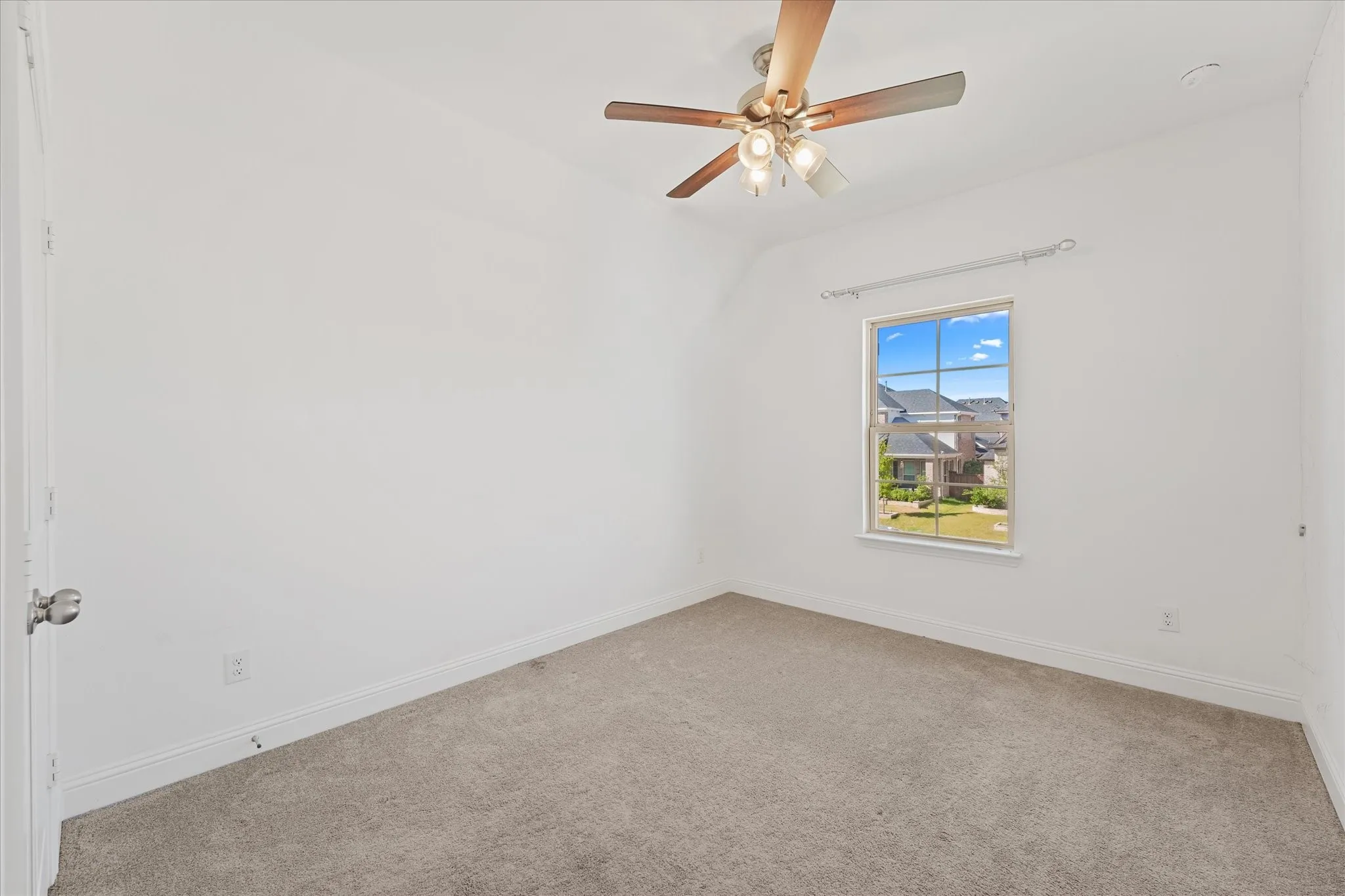 Neutral tone carpeted flooring, a ceiling fan with integrated lighting, and a white framed window