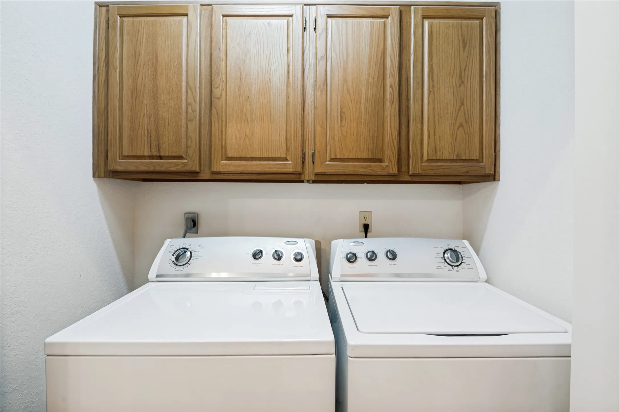 Upper wood-finish cabinetry, white wall paint