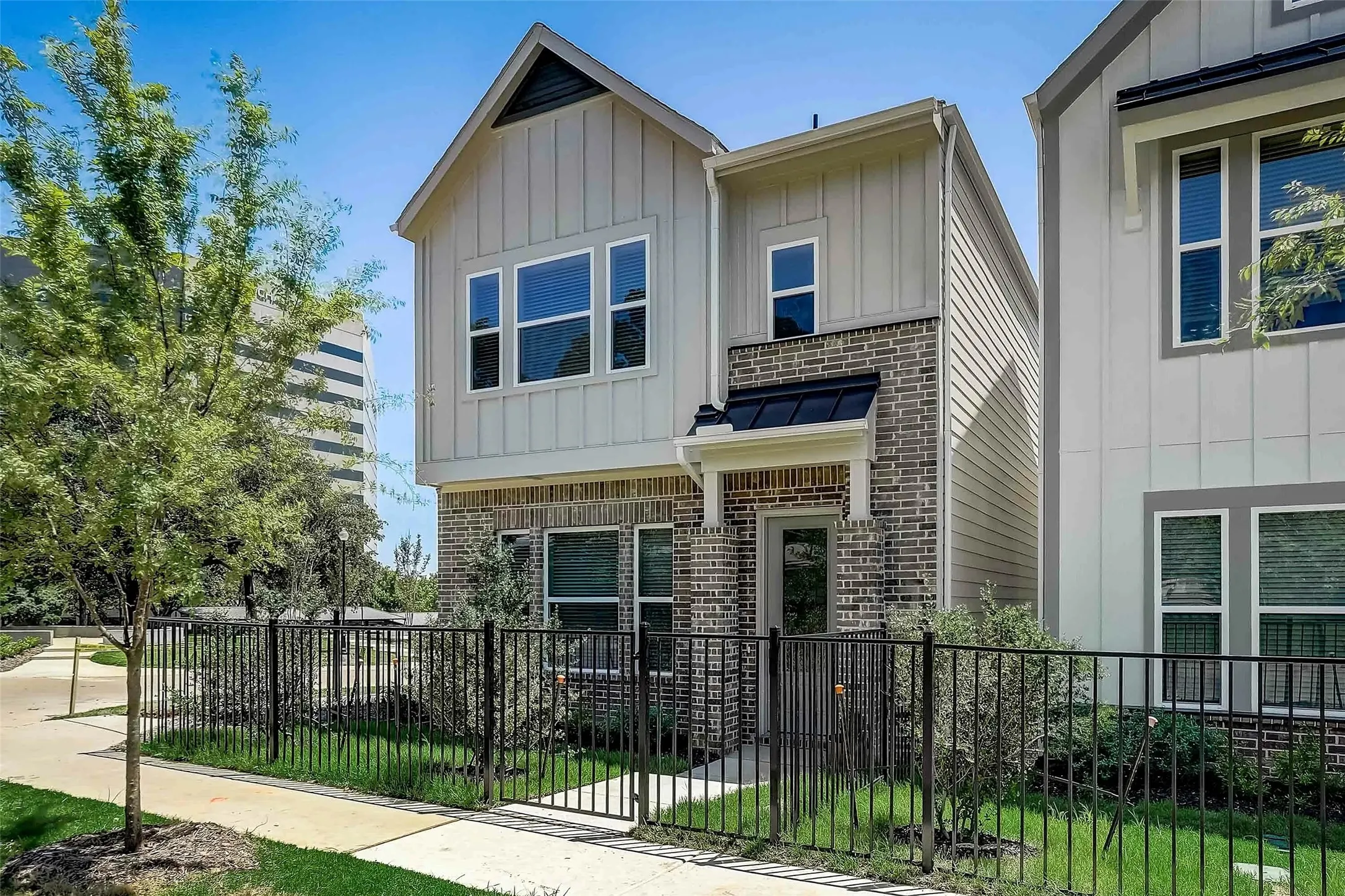 Contemporary facade featuring board and batten siding and brick accents