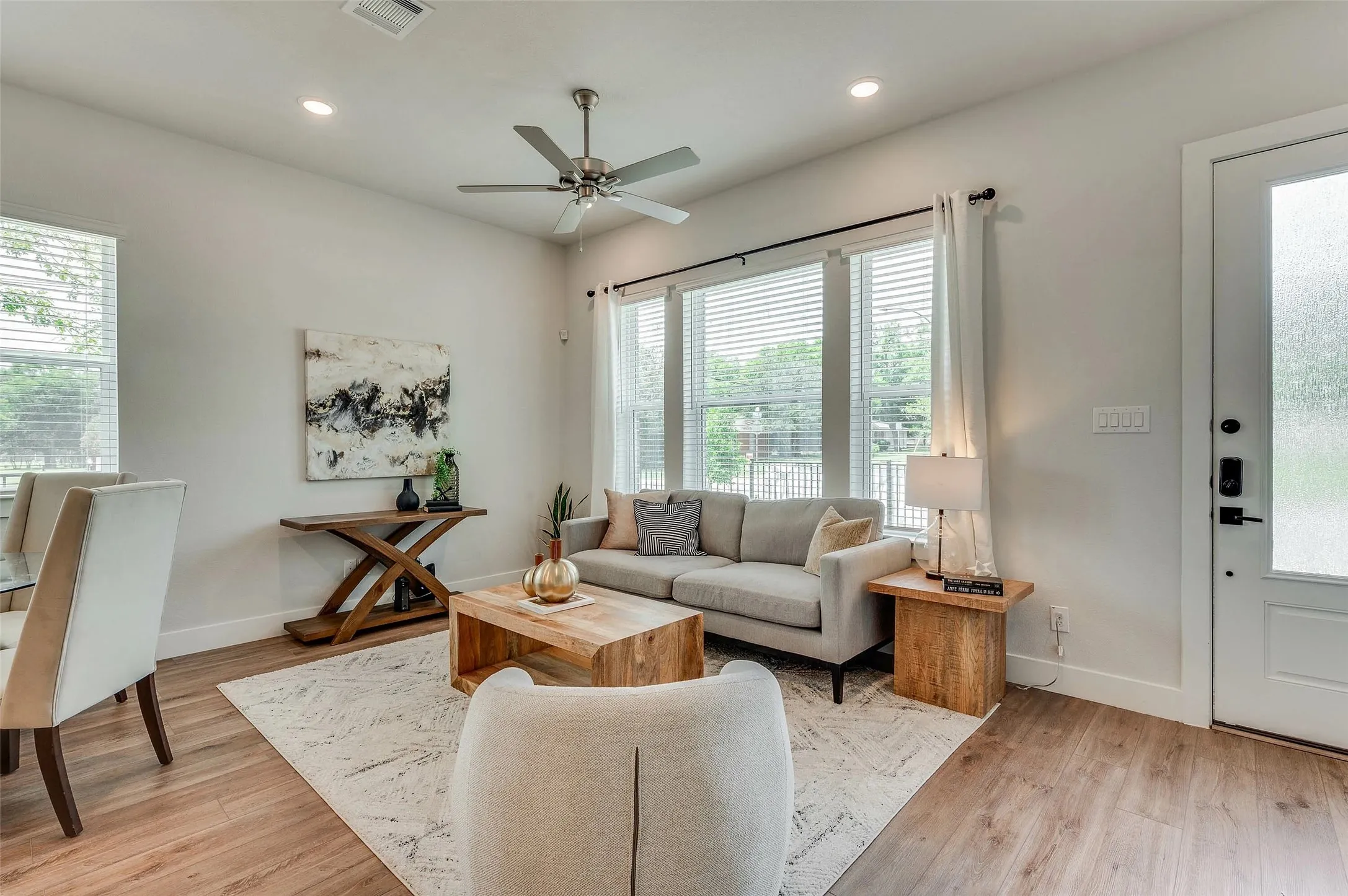 Recessed lighting, ceiling fan, wood-finish flooring, multiple windows with blinds, and white interior door
