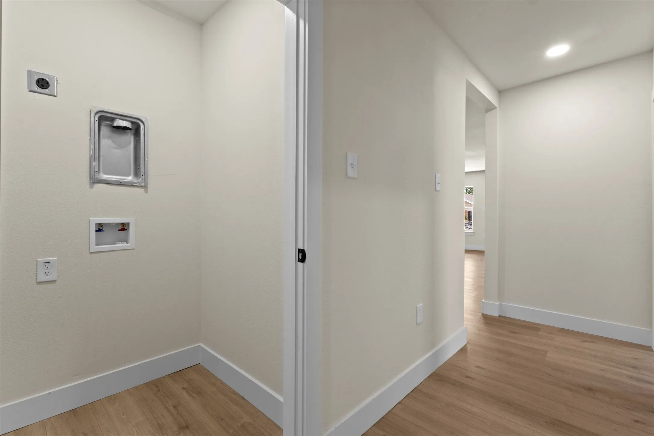 Utility closet with wood-finish flooring, light-toned walls, and recessed lighting