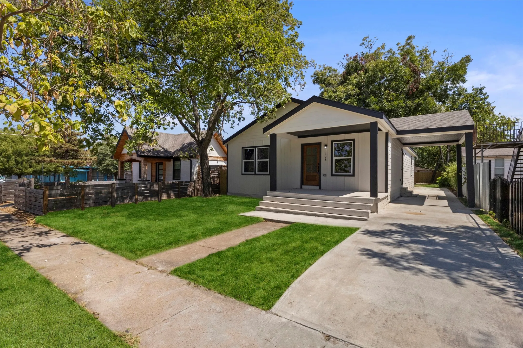 Contemporary exterior with a covered front porch, carport, and concrete driveway