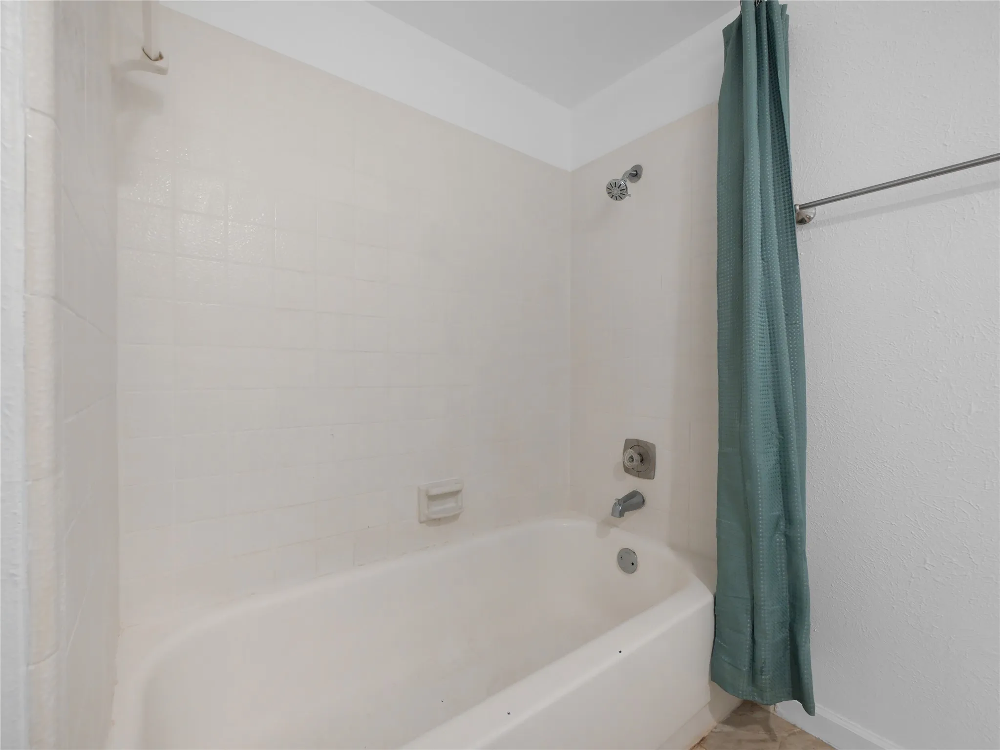 Bathtub and shower combination with white tile surround