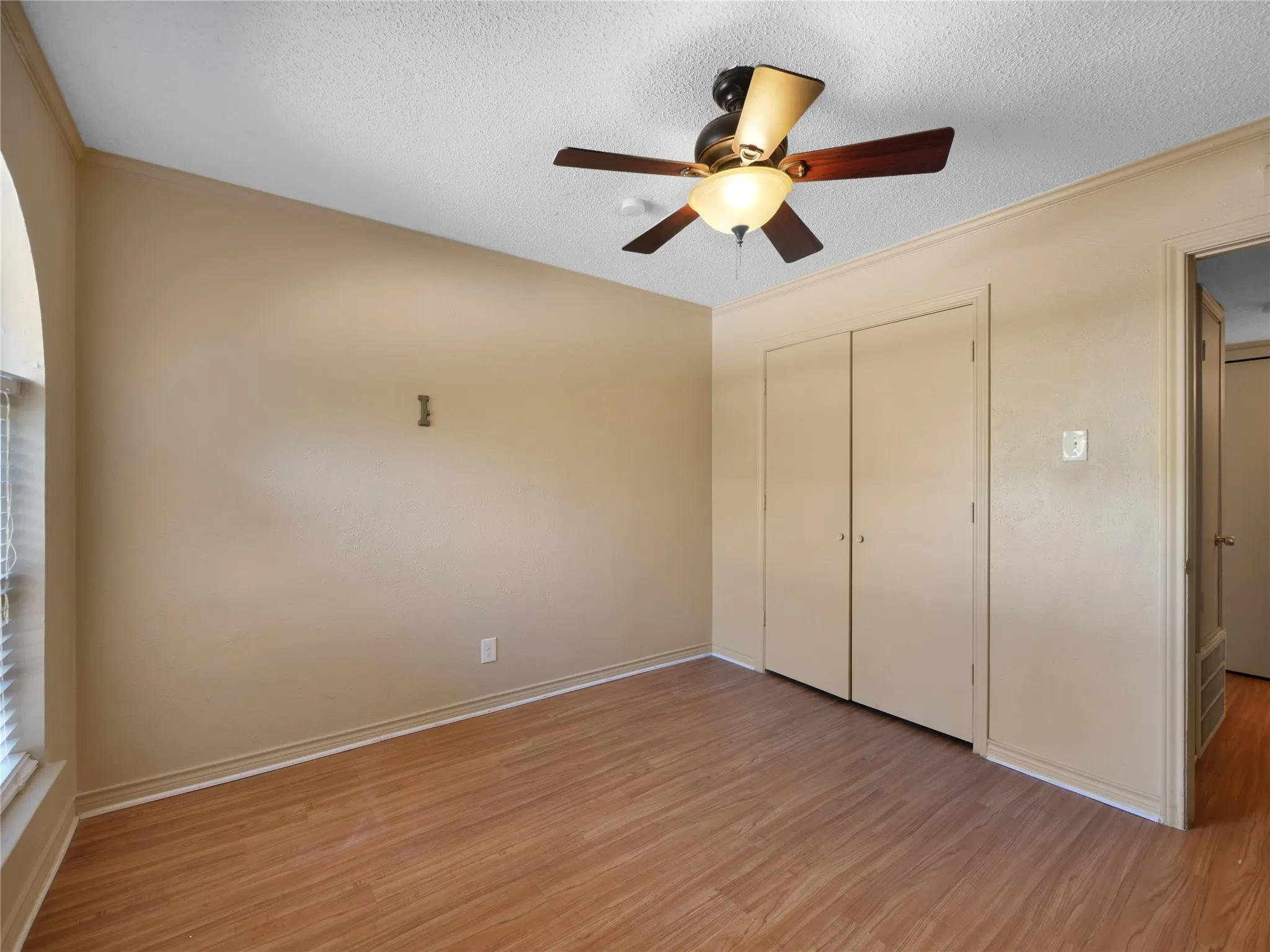 Wood-finish flooring with neutral wall tones and crown molding