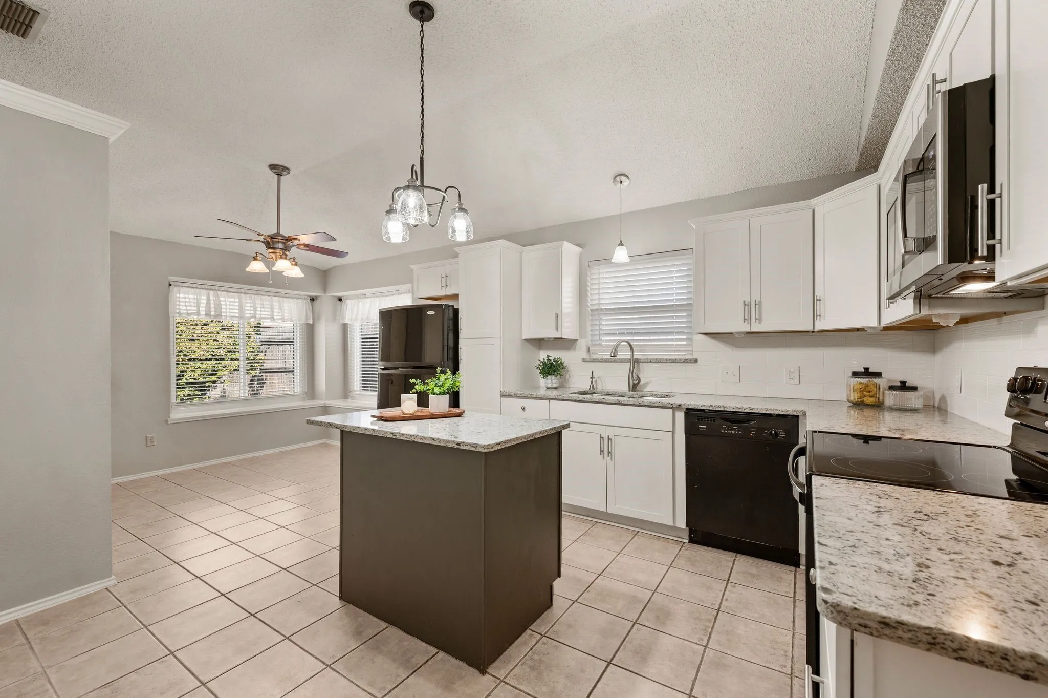 Updated kitchen features granite countertops, crisp white cabinetry, a center island & abundant workspace.