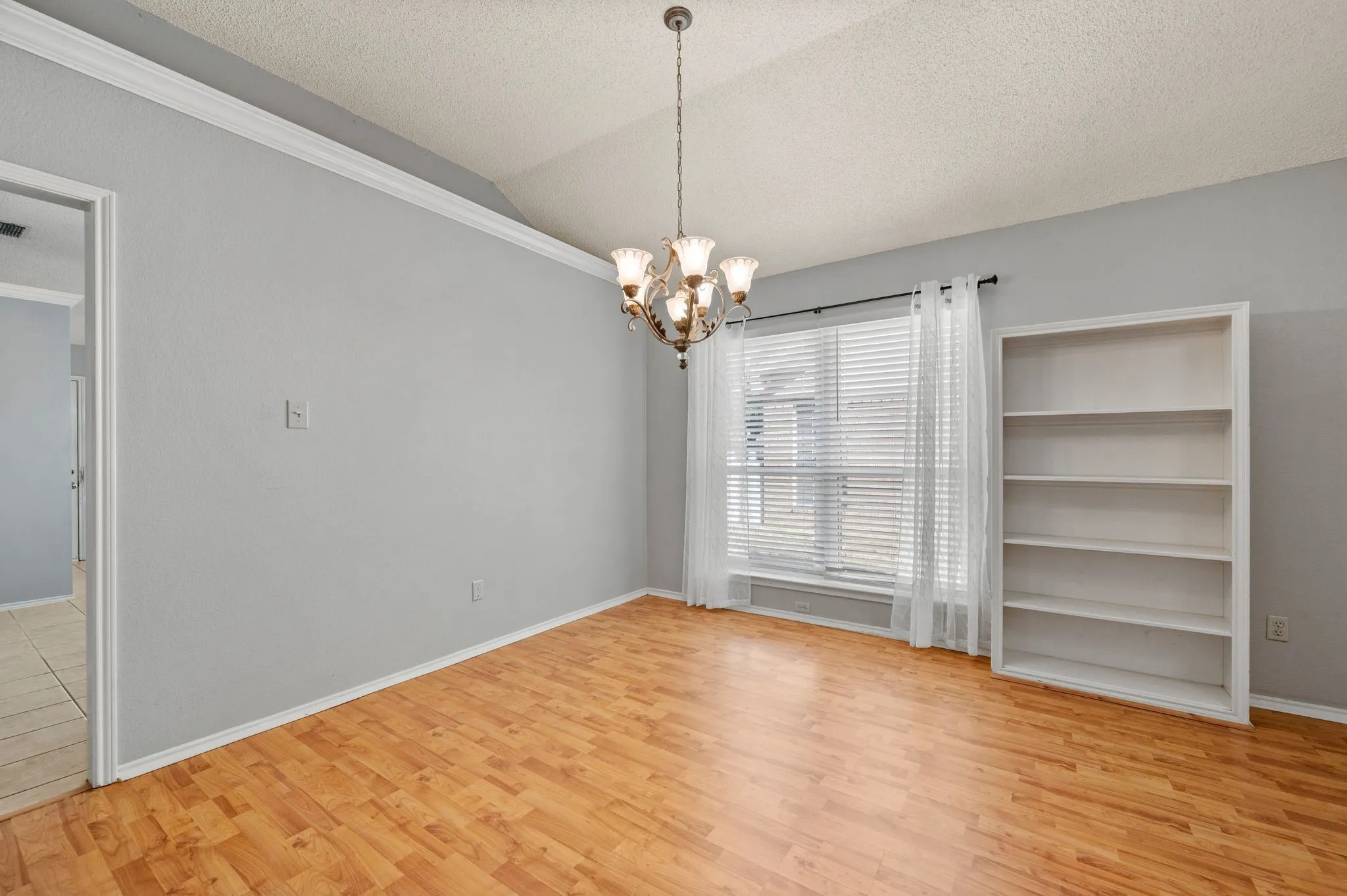 Bright dining area features decorative lighting & built-in shelving.