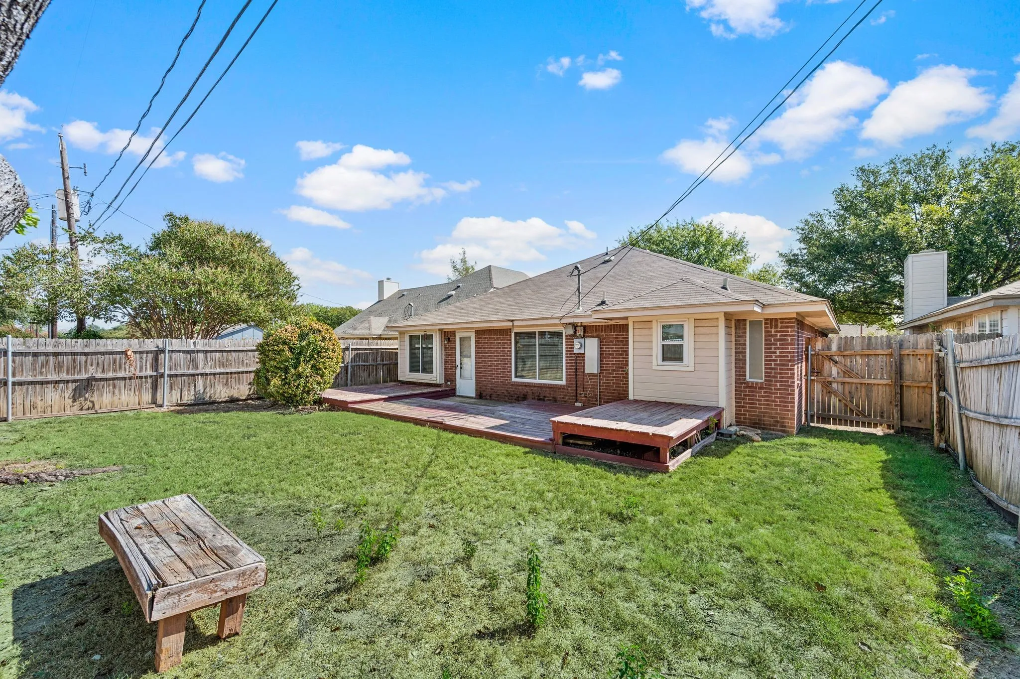 Large backyard combines grassy lawn space with an extended deck for easy outdoor living.