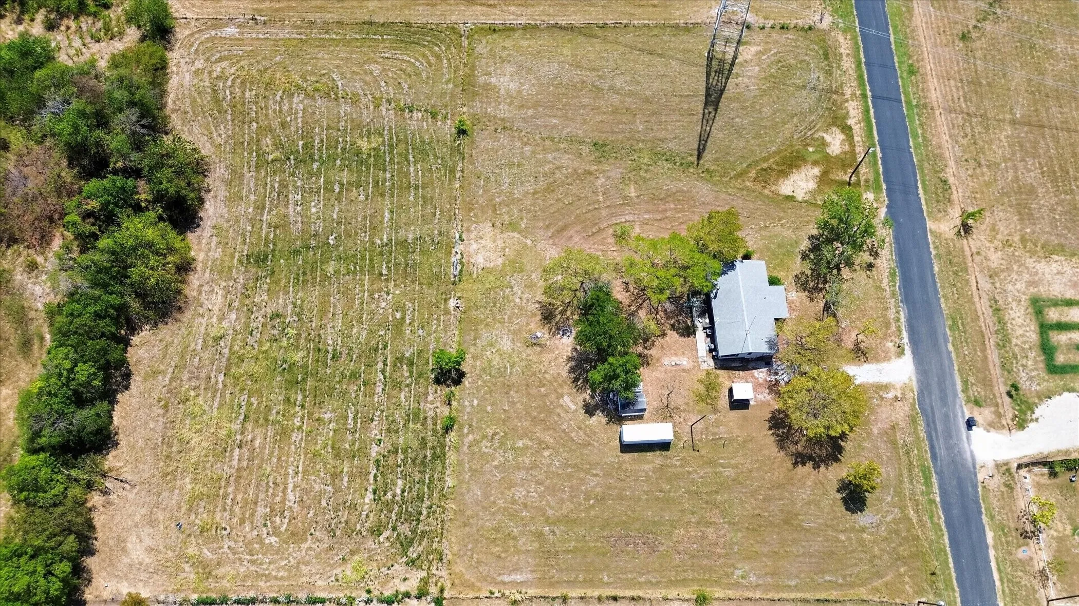 Single-story dwelling with a gray roof and surrounding mature trees