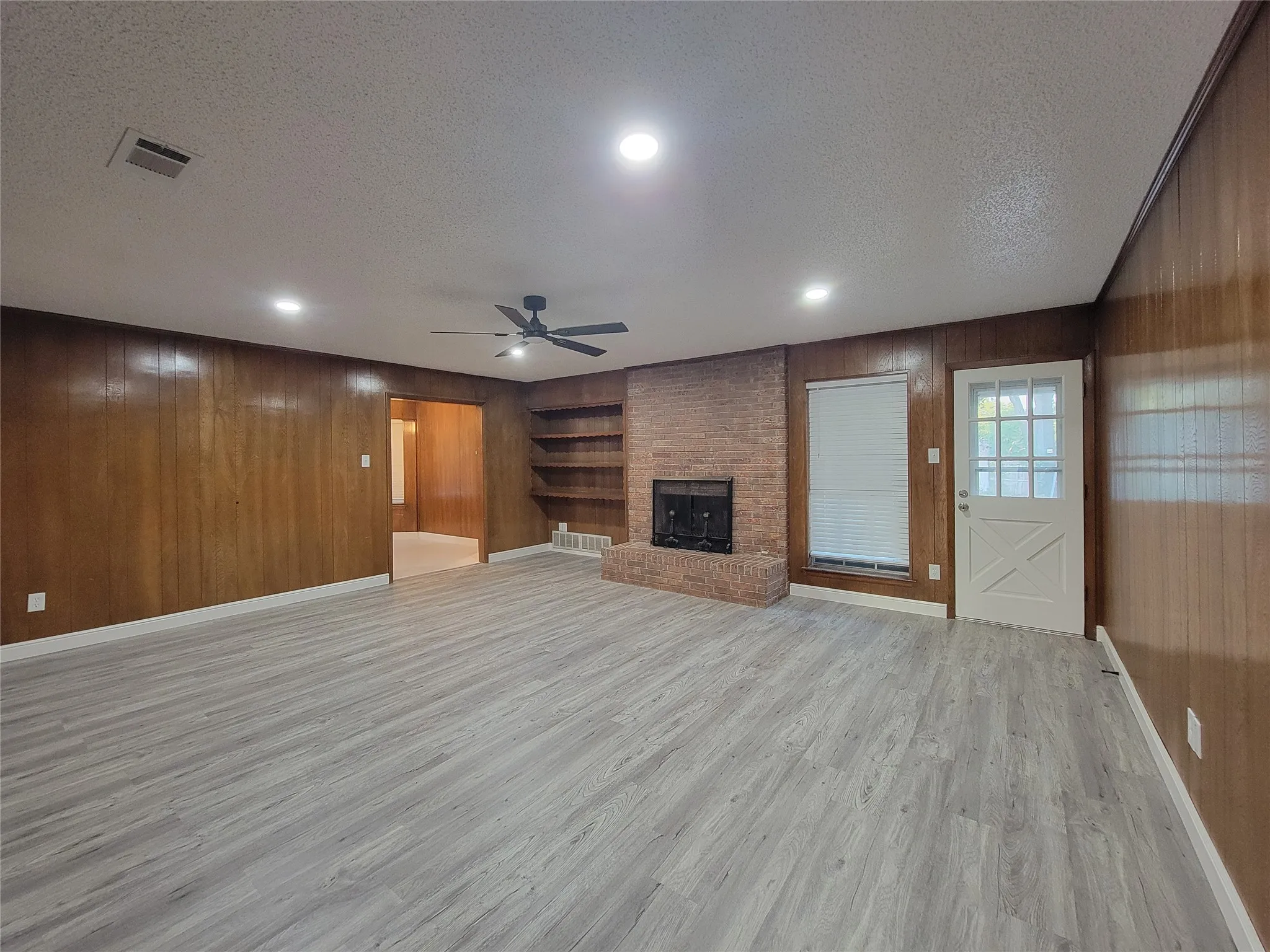 Spacious room featuring wood-finish flooring, recessed lighting, and a ceiling fan