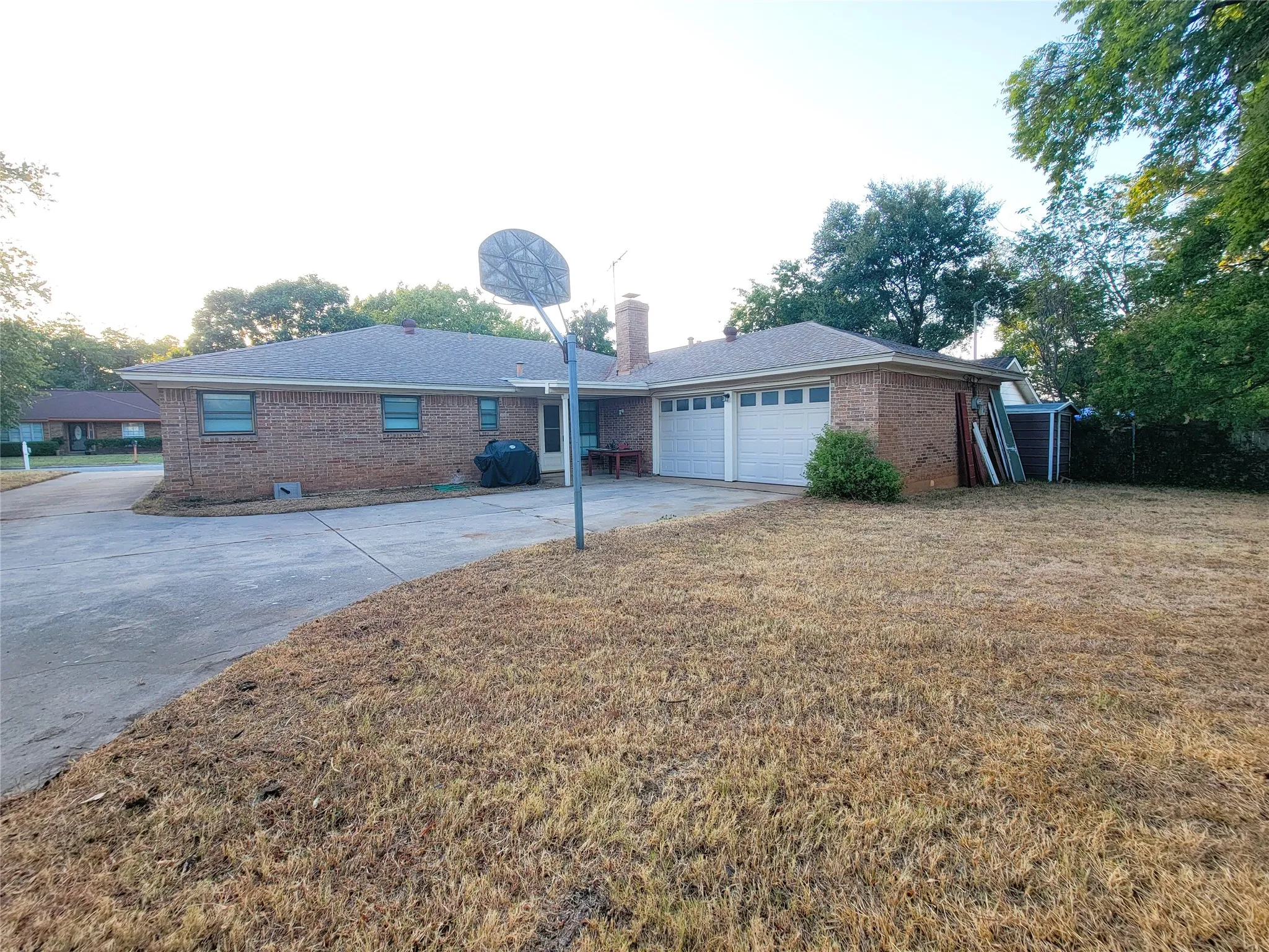 Brick exterior featuring a two-car garage and a concrete driveway