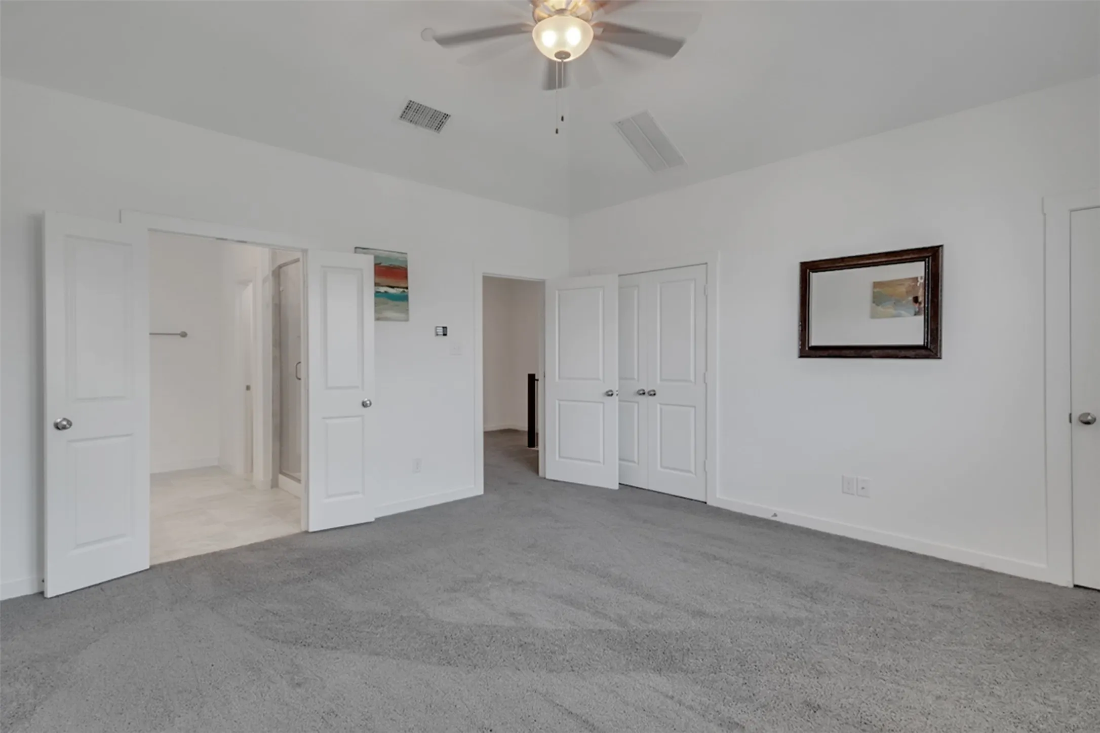 Spacious room with gray carpeting, white walls, and a ceiling fan with integrated​​‌​​​​‌​​‌‌​‌‌​​​‌‌​‌​‌​‌​​​‌​​ lighting