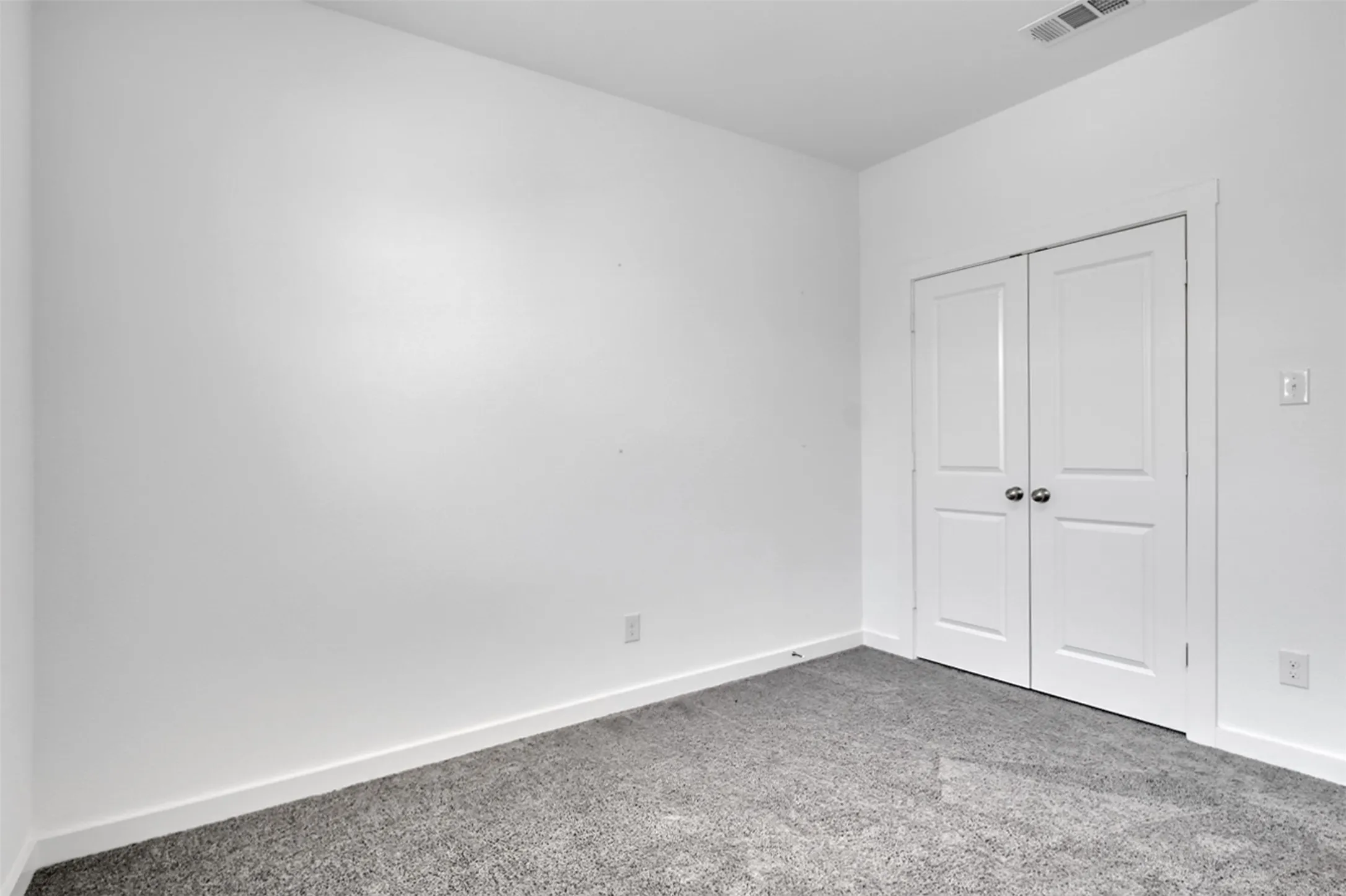 White painted walls with gray carpeting and white trim