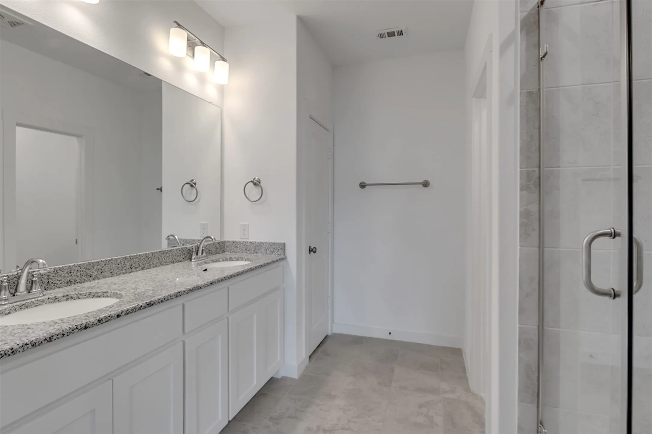 Double vanity with undermount sinks, granite-finish countertop, and brushed nickel fixtures