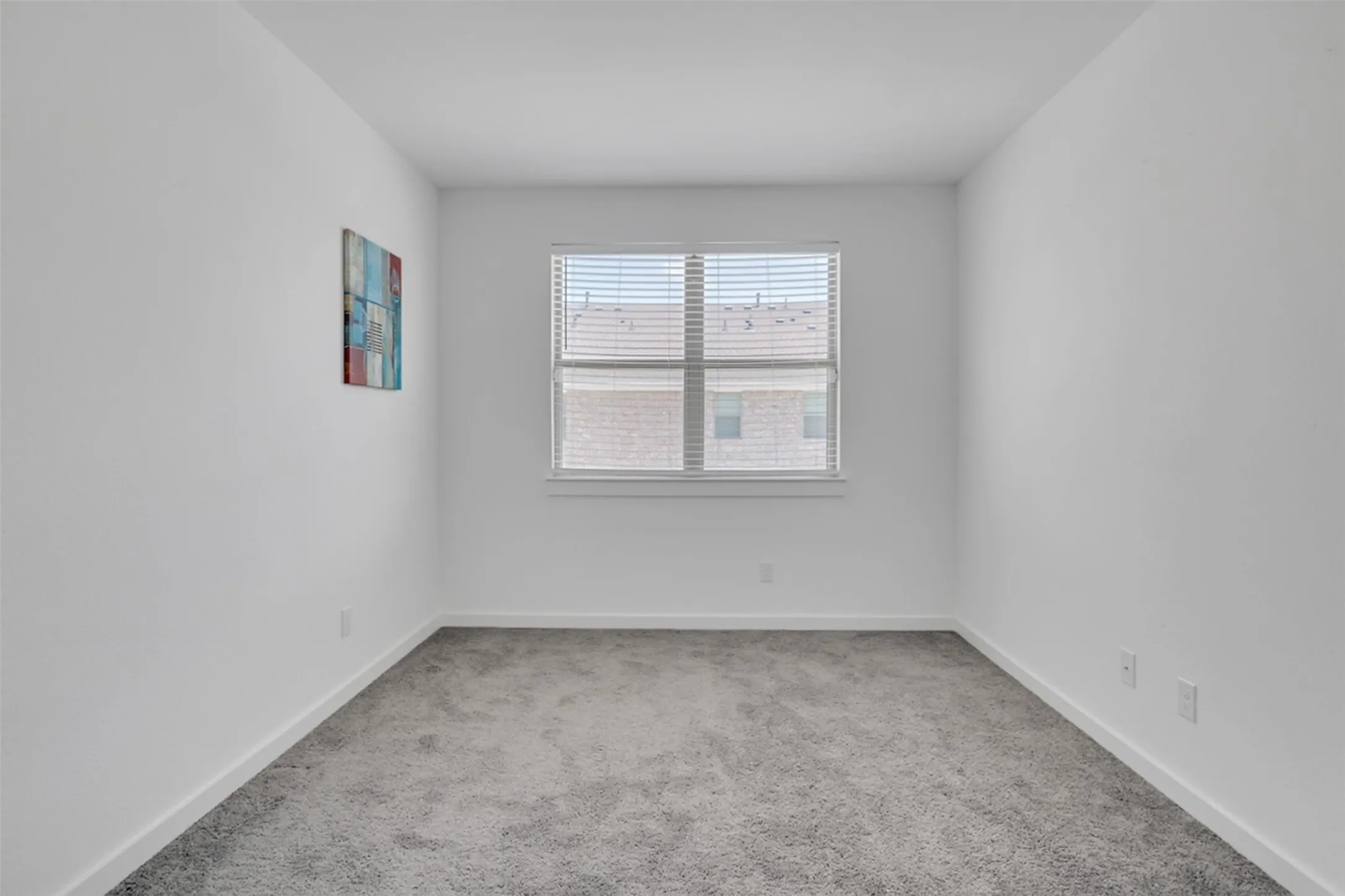 Neutral wall finishes, contemporary carpeting, and a window with horizontal blinds