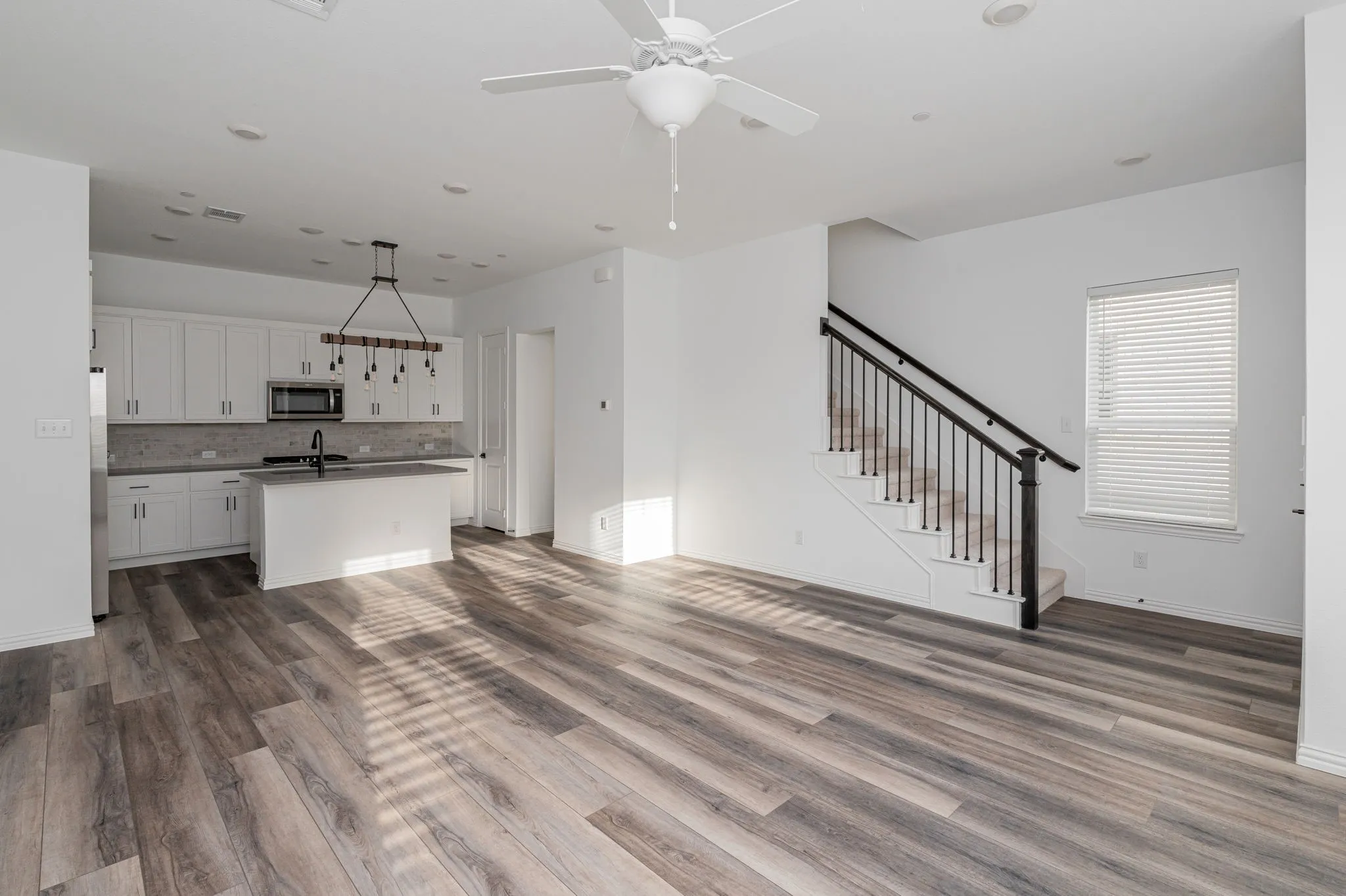 Spacious open-concept living area filled with natural light, offering a seamless connection to the kitchen—an inviting setting for everyday living and entertaining.
