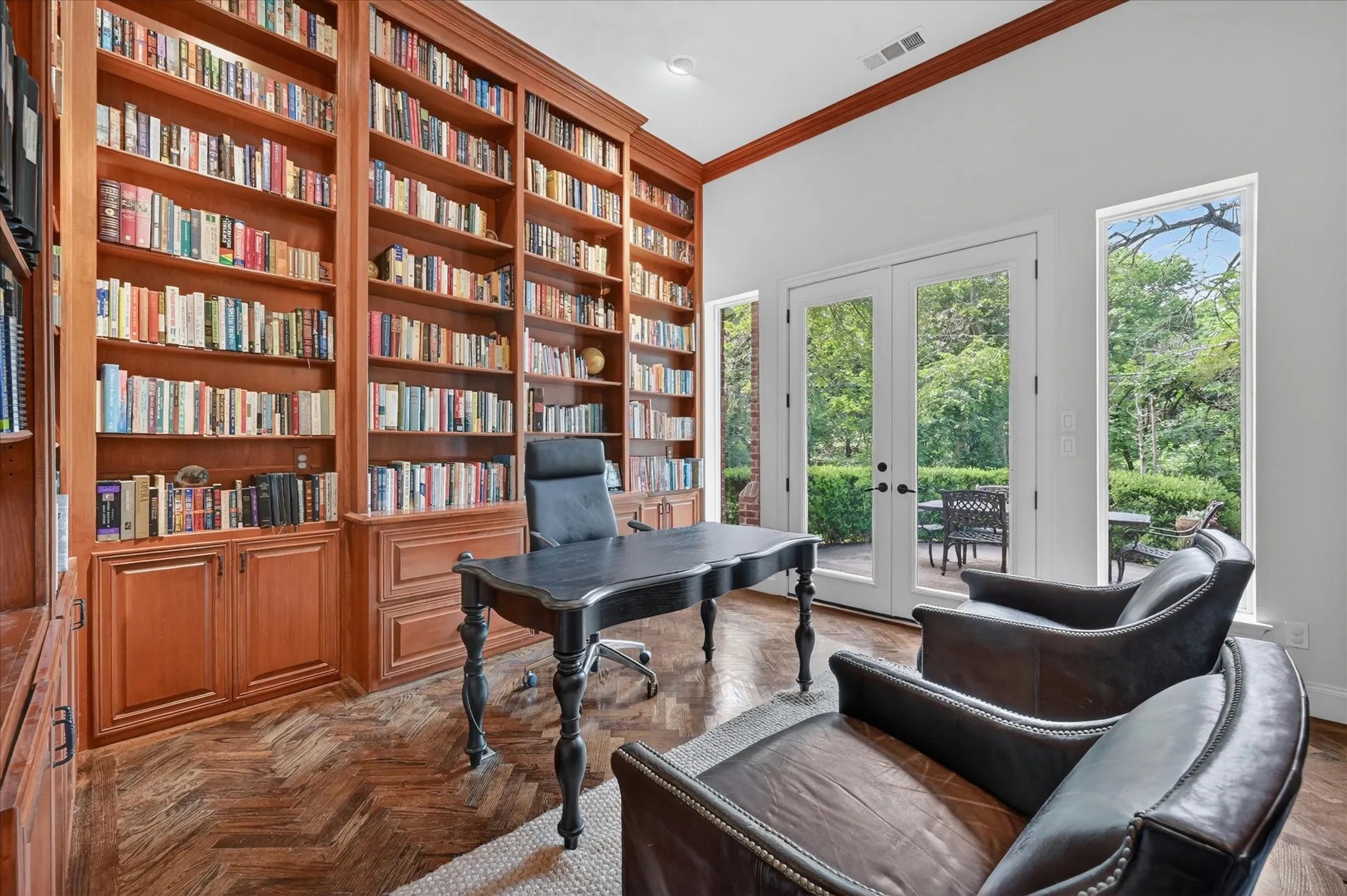 Stunning floor to ceiling built-ins, herringbone flooring, fireplace, and private patio access give this office an executive feel!