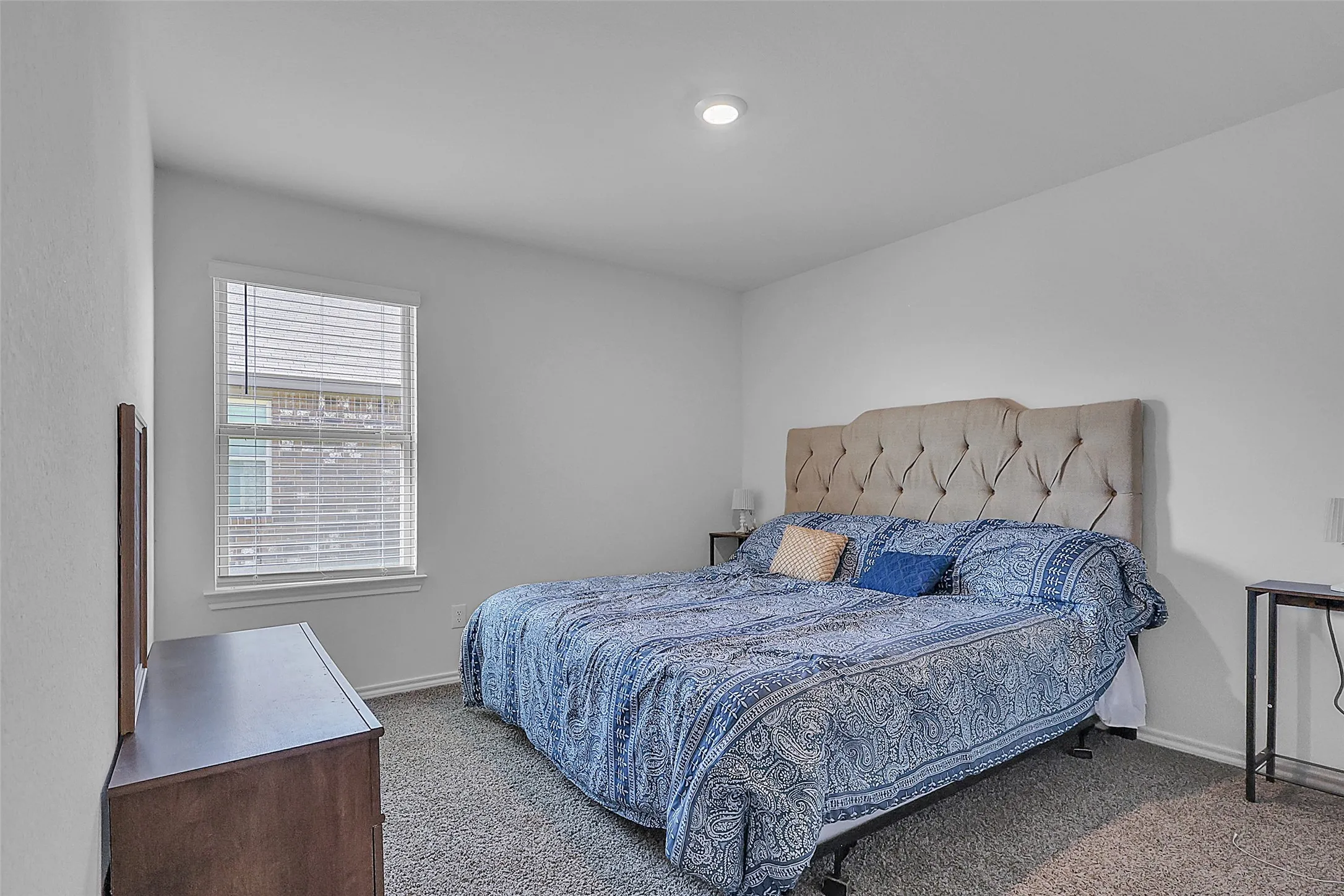 Recessed ceiling light, white walls, window with blinds, and dark carpet flooring