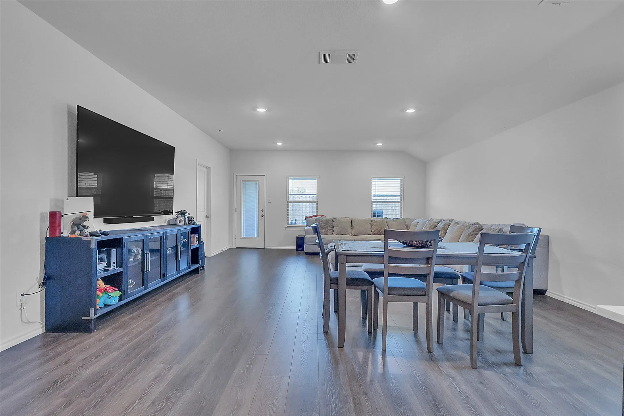 Expansive main living area featuring wood-finish flooring, recessed lighting, and multiple windows