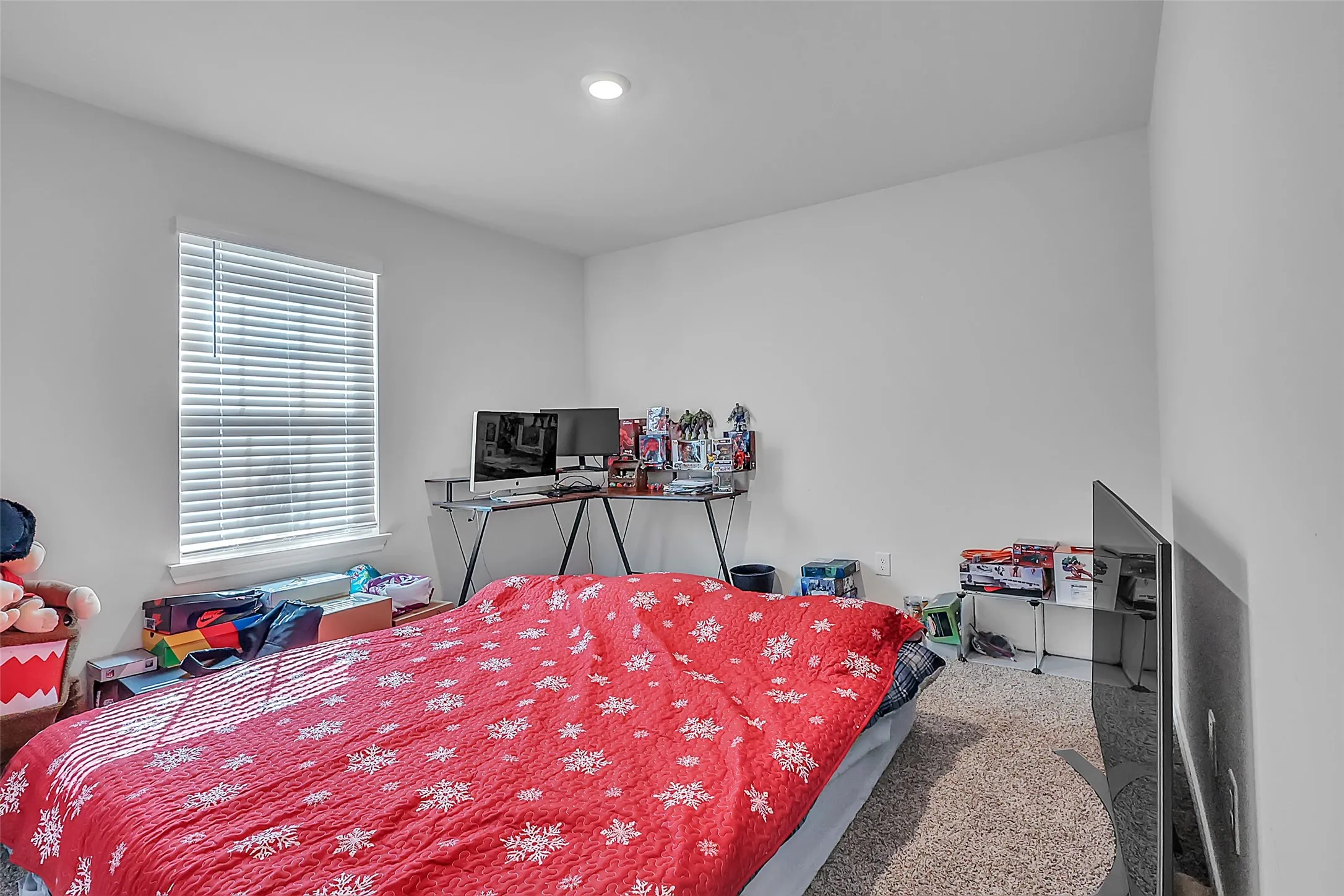 Recessed ceiling lighting, a window with horizontal blinds, and neutral wall paint